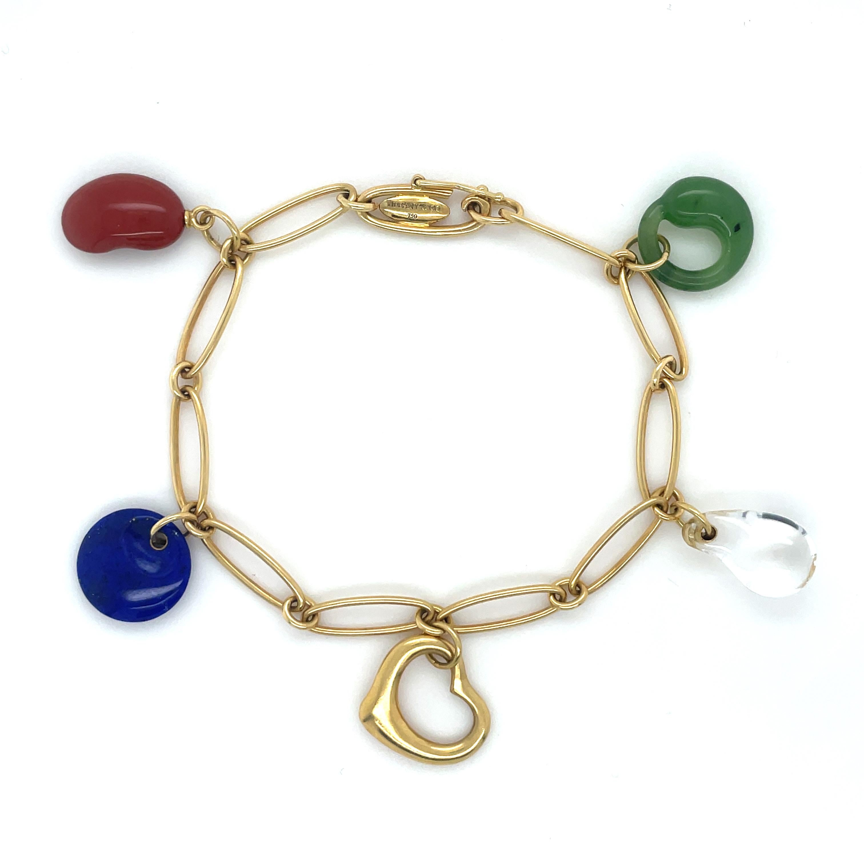 Wear five of Peretti's most beloved icons at once. Charm bracelet in 18k gold with a red jasper Bean Design, lapis lazuli disk, 18k gold Open Heart, rock crystal tear drop and green jade Eternal Circle. 

Measurements: 7 inches long
Stamp: TIFFANY