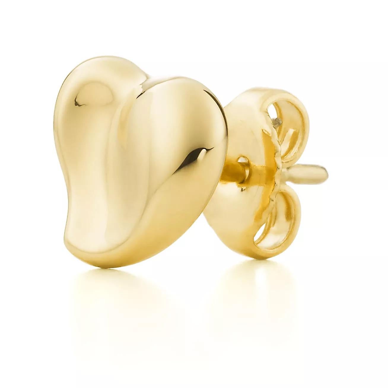 Beautiful pair of earrings by famed designer Elsa Peretti for Tiffany & Co. The pair are crafted in solid 18k yellow gold and known as the Full Heart stud earrings. Peretti's take on a heart design in luscious yellow gold that sit perfectly on the