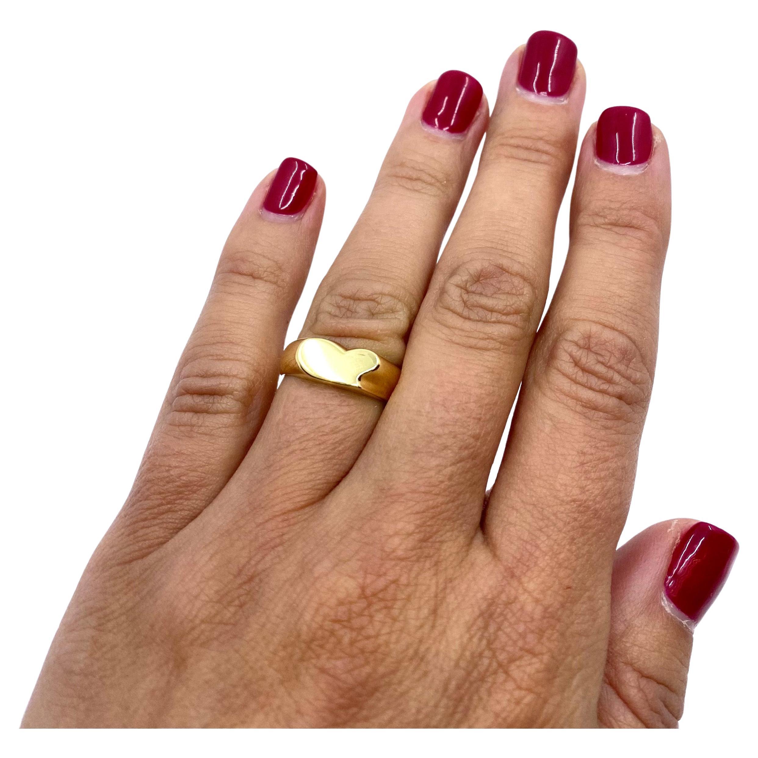 A minimalist Heart ring by Elsa Peretti for Tiffany & Co., made in 18k gold. The ring is crafted as a gold band with a flat stylized heart design. The smoothness of the polished gold and seamless lines of the ring create a perfect shape. With all