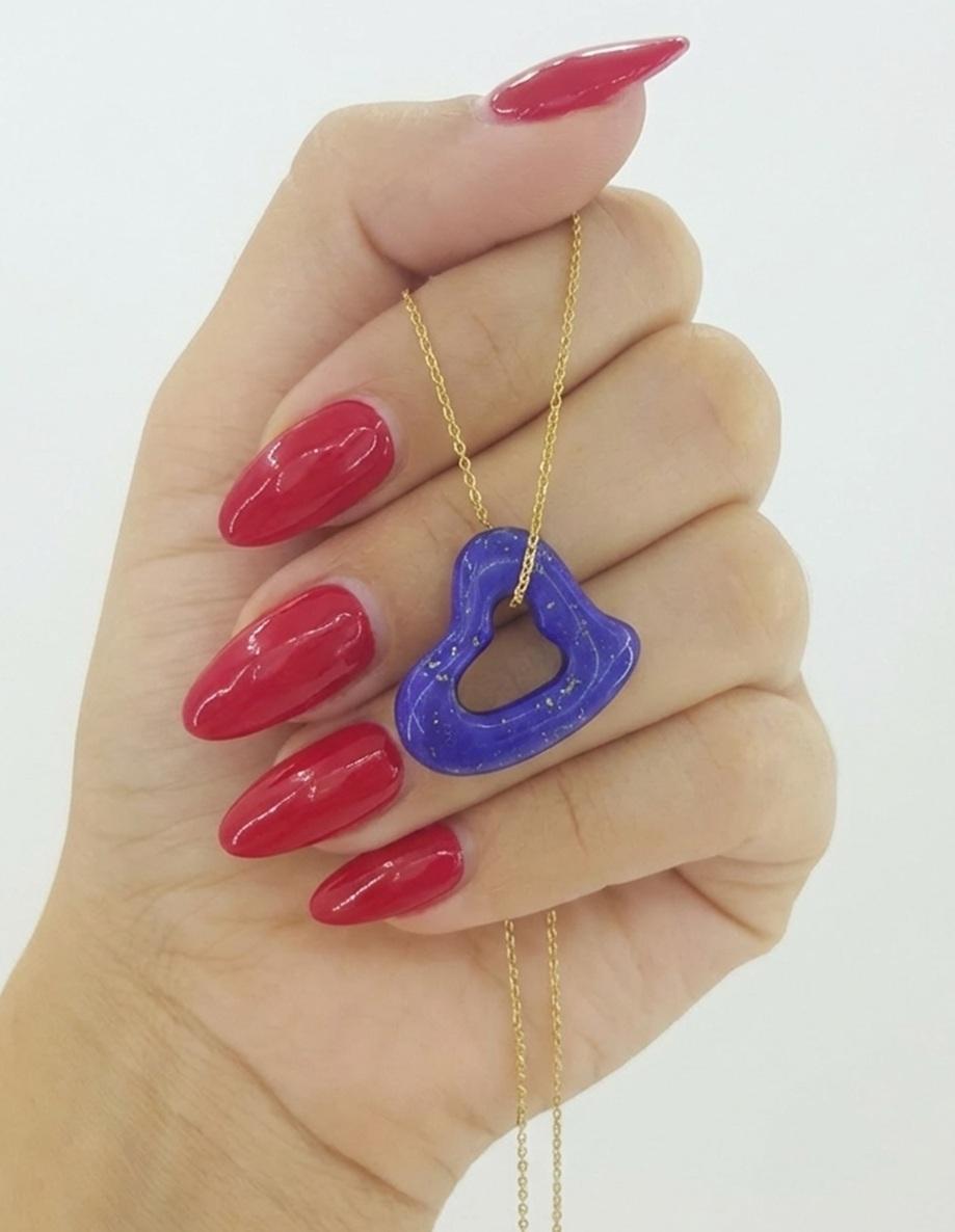 Este elegante collar Tiffany & Co. incluye el icónico diseño Corazón Abierto de la renombrada diseñadora Elsa Peretti, bellamente elaborado en oro amarillo de 18 quilates y engastado con un escultural colgante de lapislázuli. El profundo tono