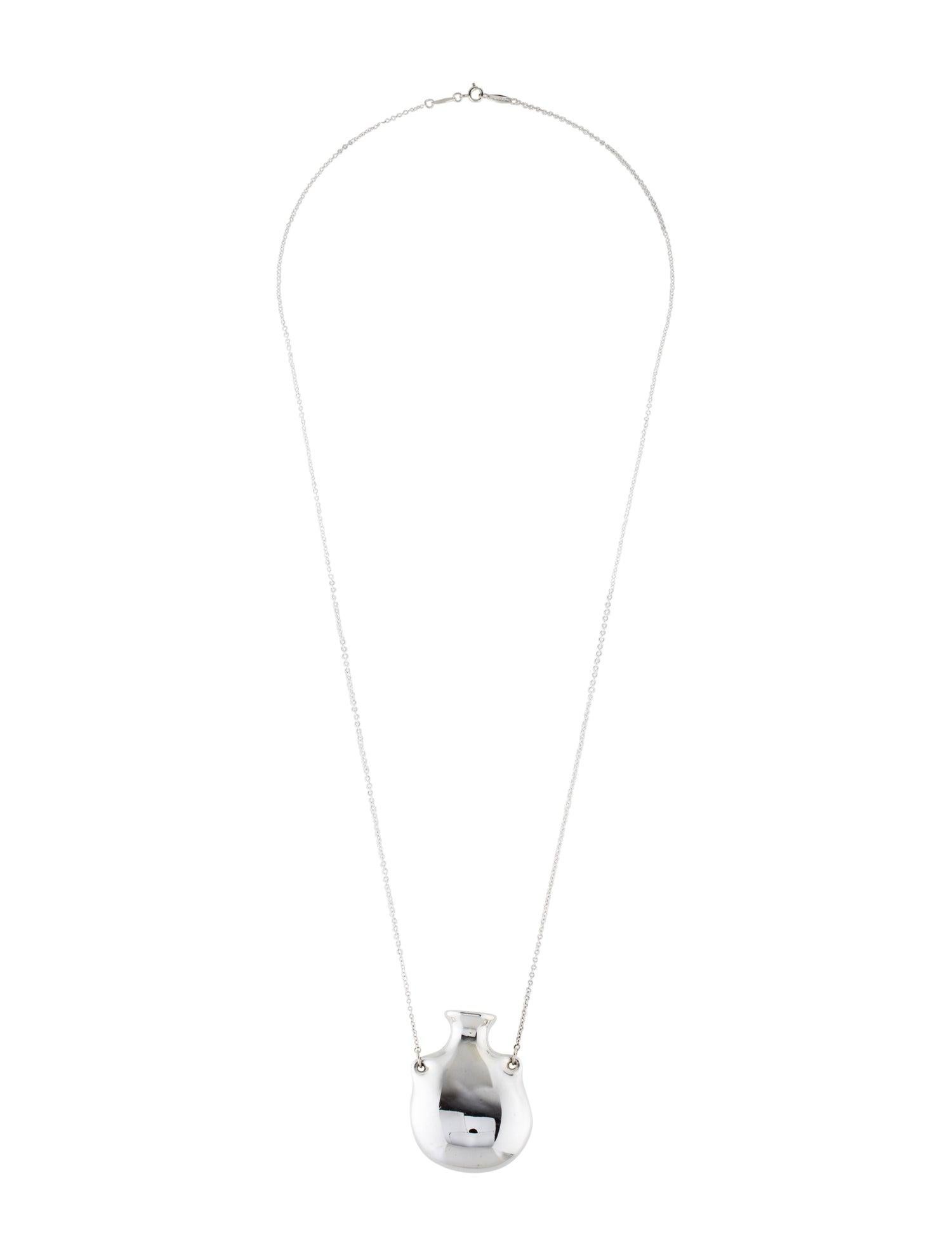 This Tiffany and co Elsa Peretti pendant captivates with its 27mm by 22mm open bottle design that hangs from a single bale. This enticing pendant was crafted in Spain in Sterling silver. It is 25 inches long and weighs 12.6 grams. 
