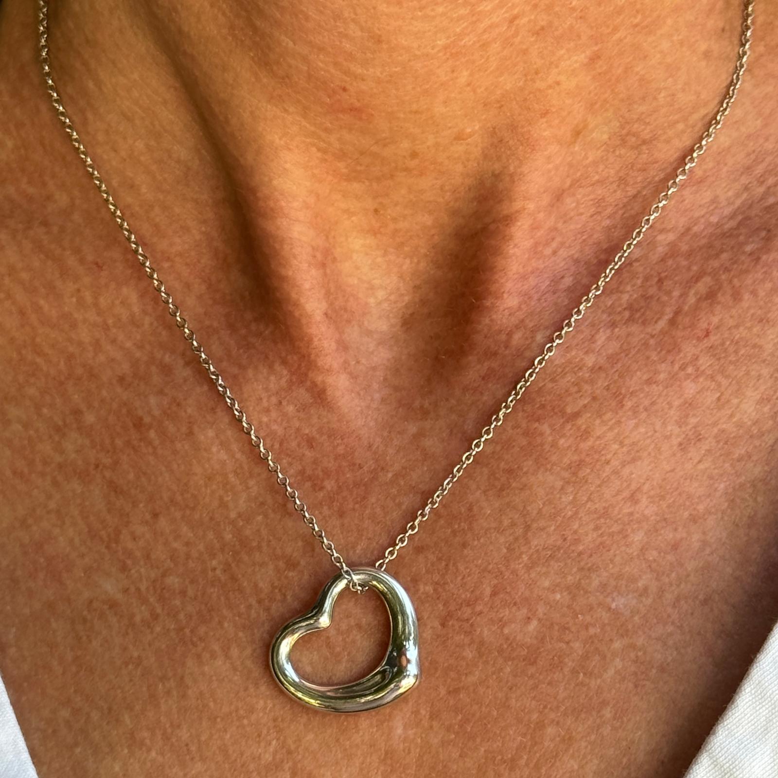 Tiffany & Co. Elsa Peretti open heart pendant fashioned in sterling silver. The pendant measures 20mm and the necklace measures 16 inches in length. Signed Tiffany & Co. Elsa Peretti 925 Spain. Weight: 6.8 grams.