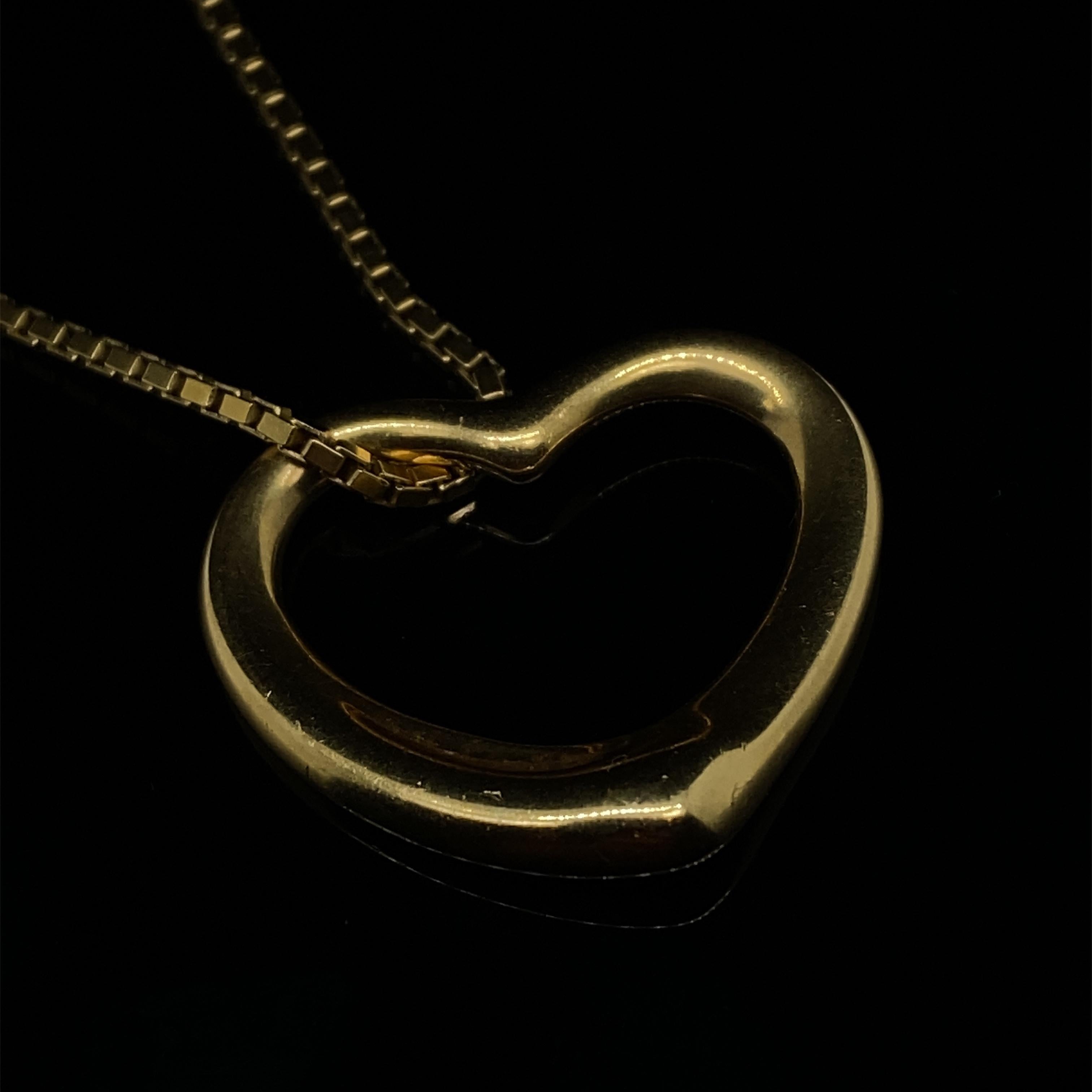 A Tiffany & Co. Elsa Peretti open heart 18 karat yellow gold pendant necklace.

Comprising of an 18 karat yellow gold open heart pendant, suspended on an 18 karat yellow gold fine box chain. 

The simple and elegant open heart is one of Elsa