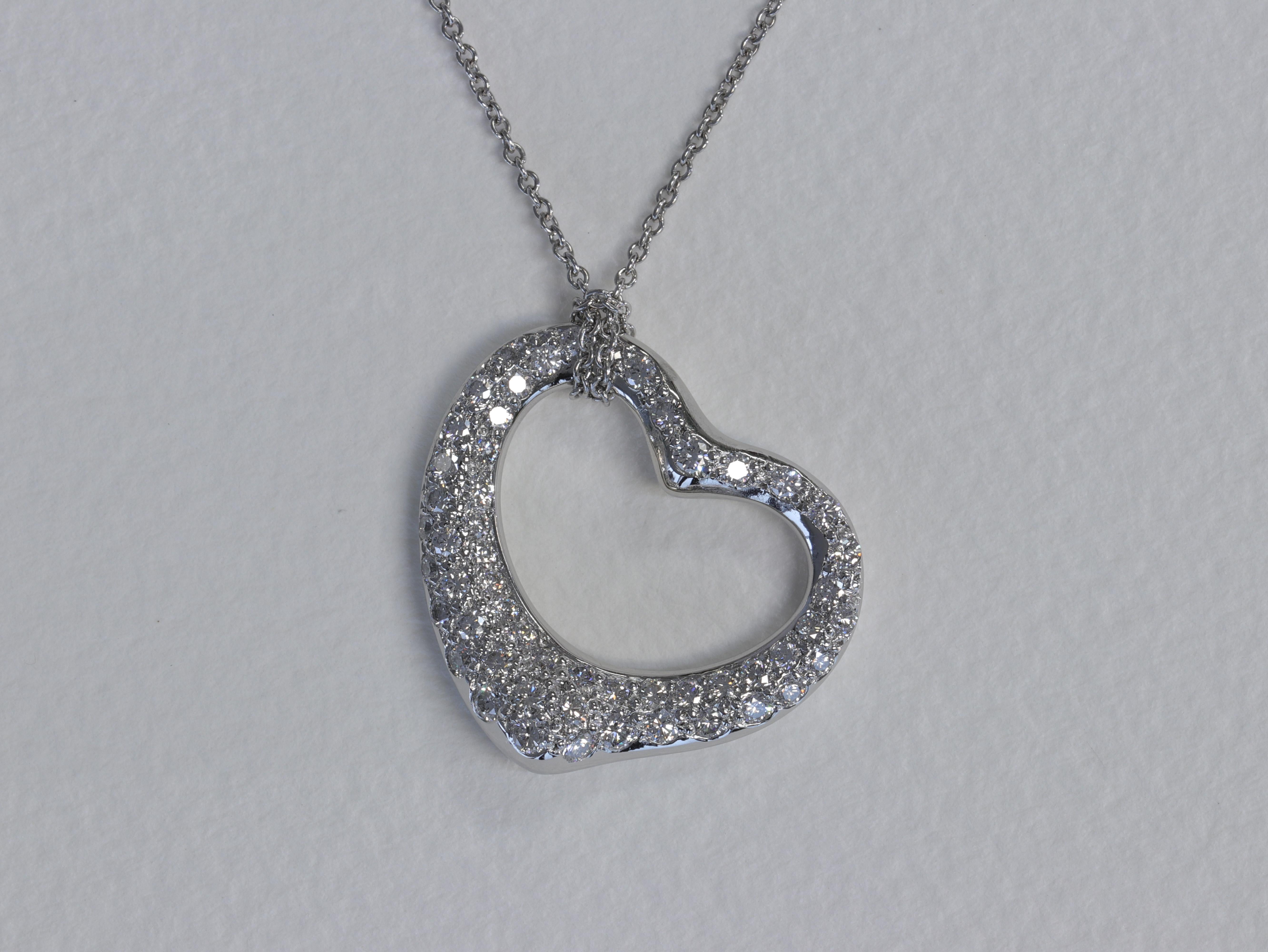 A timeless Elsa Peretti design for Tiffany & Co. the pave diamond and platinum Open Heart pendant on a platinum Tiffany & Co. chain. 

The diamonds are round brilliant cuts and are fine quality with colors of E-F and clarities of VS1+.

The pendant
