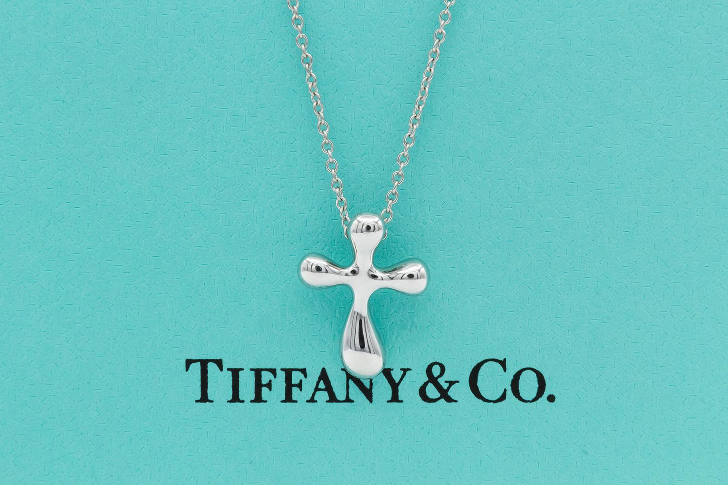 We are pleased to offer this Authentic Tiffany & Co. Elsa Peretti Platinum Cross Pendant Necklace. Elsa Peretti, a true pioneer of design, translates all she sees in the natural world into jewelry that is sculptural, organic and irresistibly