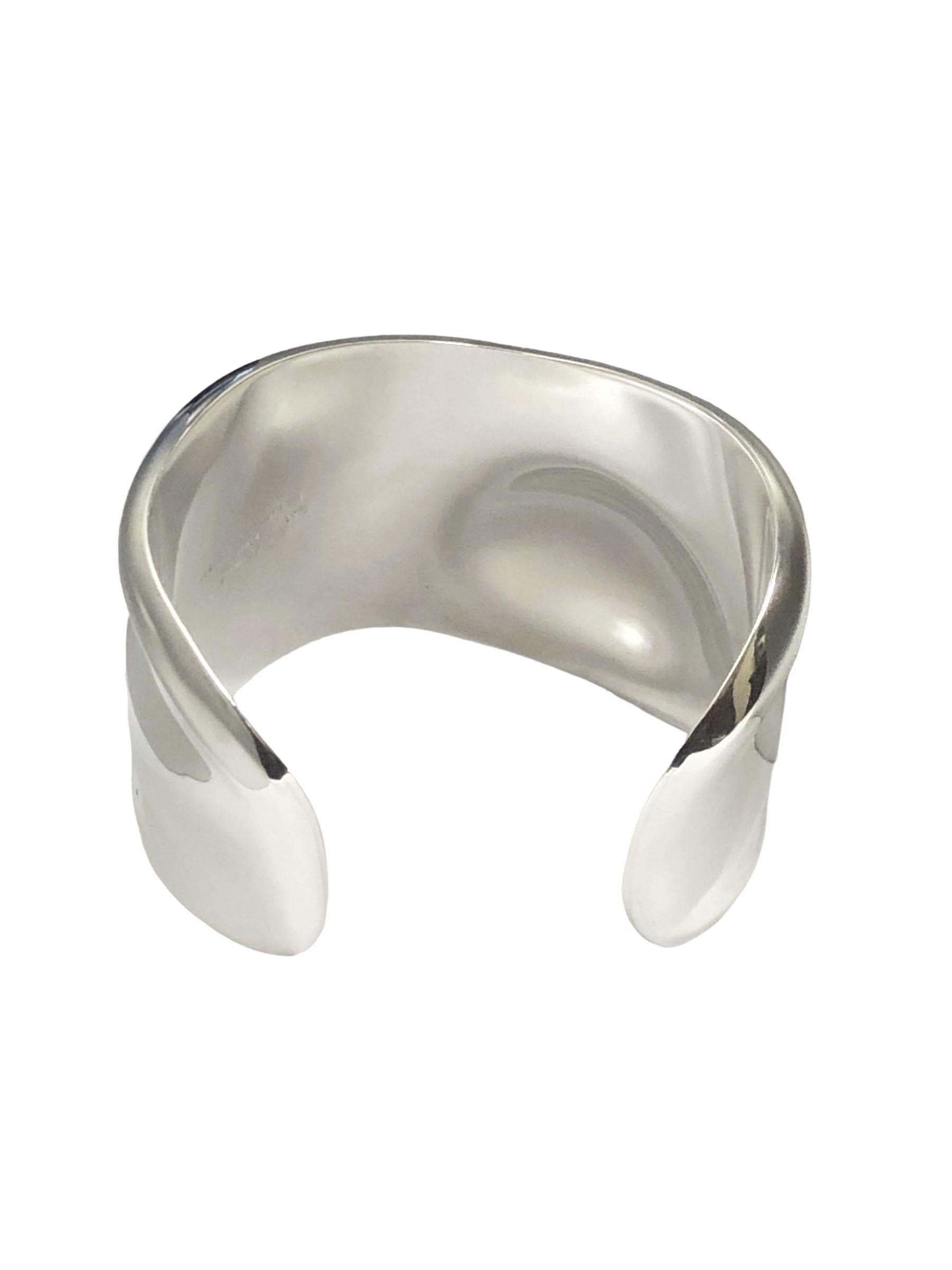Circa 1975 Elsa Peretti for Tiffany & Co., Sterling Silver Bone Cuff Bracelet. Measuring 2 inches at its widest point, an opening of 1 inch and is plyable to be opened a bit more. Inside measurement of approximately 6 1/8 inch, This is the medium to