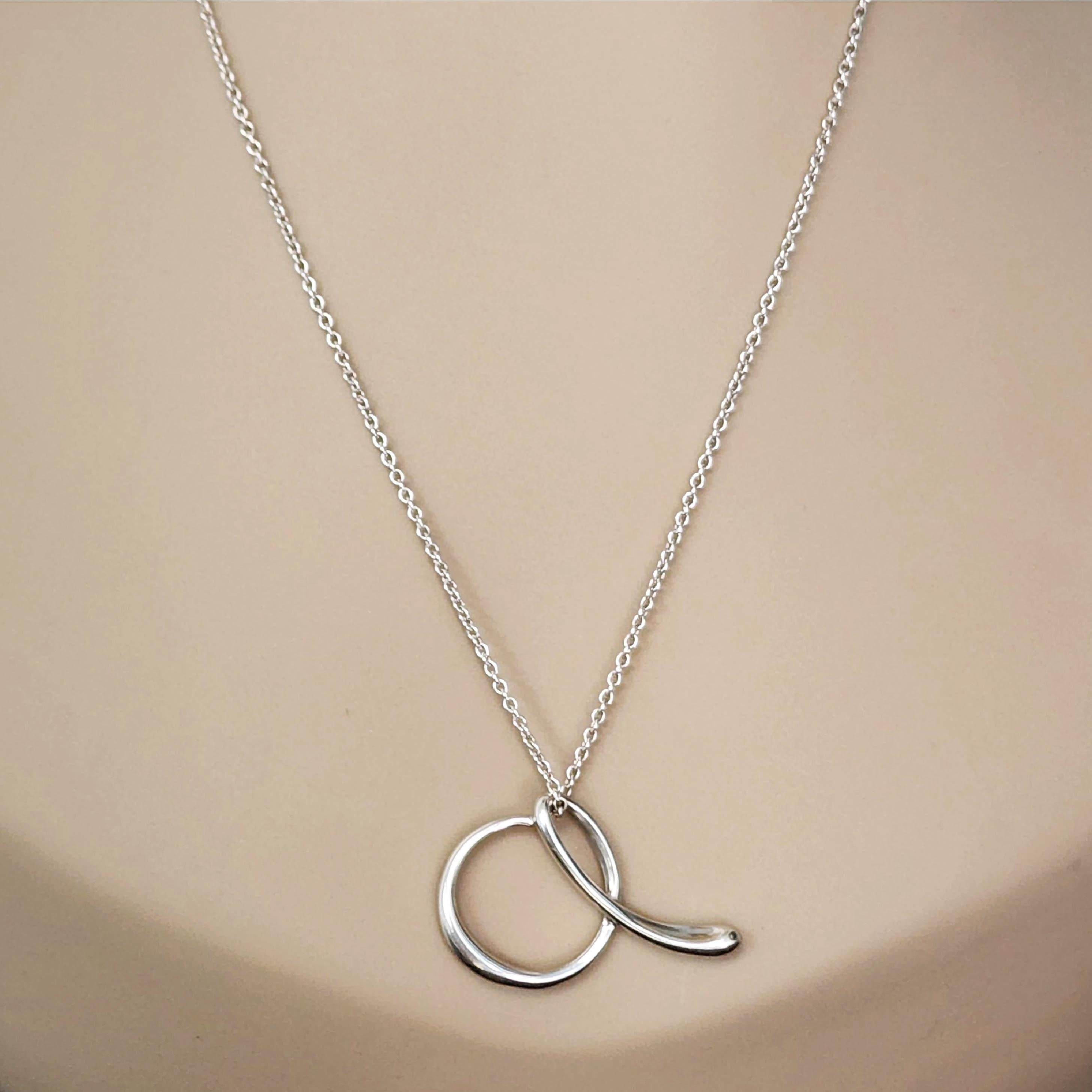 Tiffany & Co sterling silver letter A charm pendant with chain necklace by Elsa Peretti.

An authentic Tiffany & Co necklace featuring a script letter A pendant from Elsa Peretti's Alphabet collection, on a delicate chain. Does not include Tiffany &