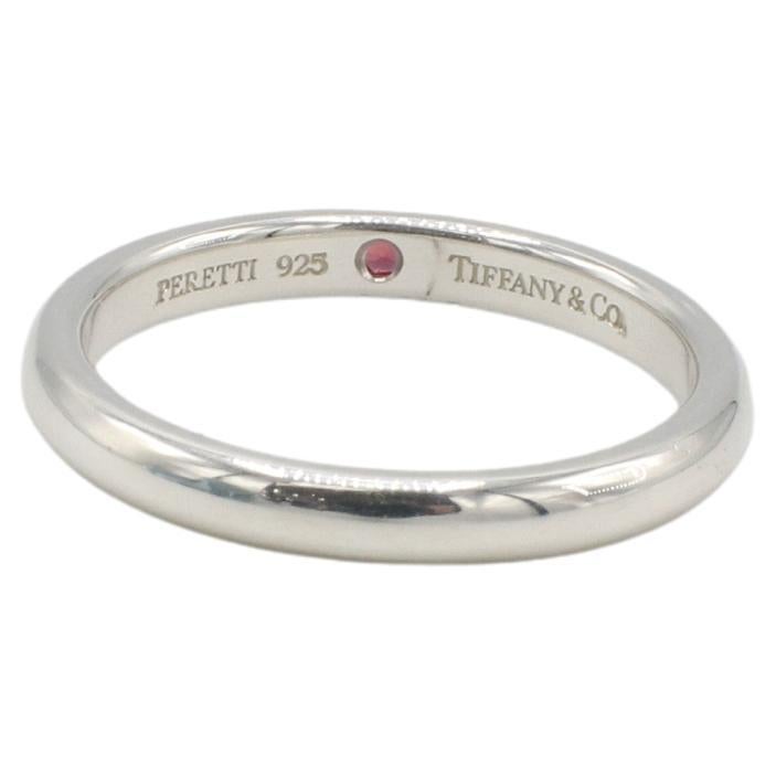 Tiffany & Co. Bague Elsa Peretti en argent Sterling Ruby incrusté de rubis naturel
Métal : Argent sterling 925
Poids : 2.79 grammes
Rubis : Environ 0,03 carats
Taille : 7.5
Largeur : 2.5mm
Signé : Tiffany & Co. PERETTI 925 
AT F35000890