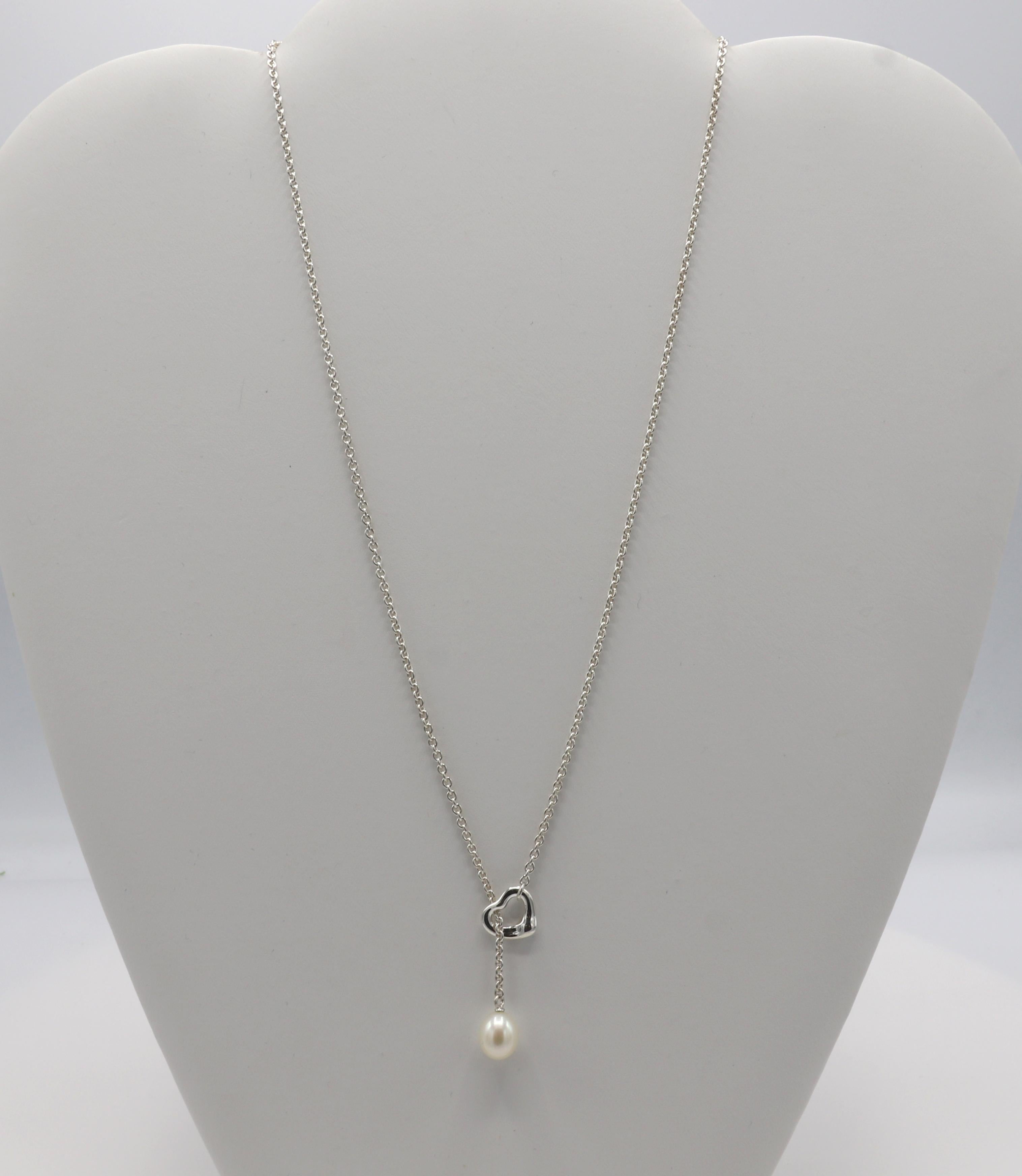 Tiffany & Co. Elsa Peretti Sterling Silver Open Heart Pearl Lariat Drop Necklace 
Metal: Sterling silver 925
Weight: 5.96 grams
Length: 19 inches
Pearl: 7.5 x 9mm
Heart: 10 x 9mm
Signed: Tiffany & Co. Peretti Spain Ag925