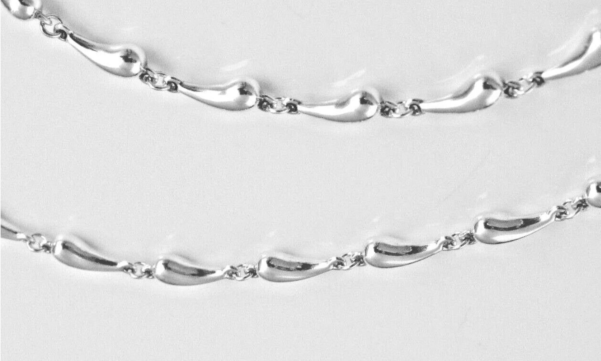 Rappelant les gouttes de pluie. Le collier est composé d'une chaîne de 16 pouces en argent sterling.  N'est plus fabriqué par Tiffany's. Fermoir à mousqueton. Utilisé, mais en bon état. Les designs originaux sont protégés par copyright par la