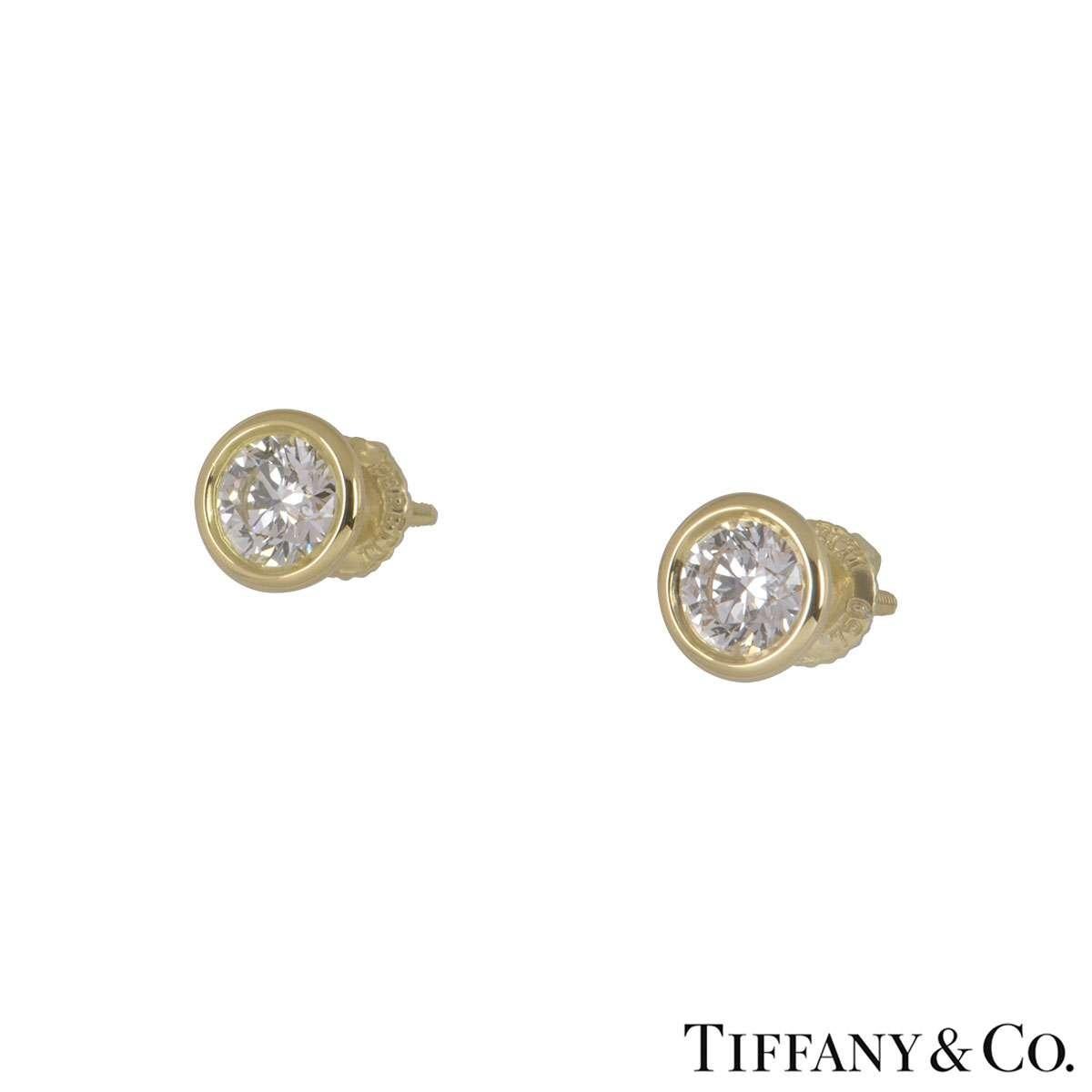 An 18k yellow gold pair of earrings by Tiffany & Co. from the Elsa Peretti collection. The earrings are composed of an round brilliant cut diamond in a rubover setting. The total diamond weight is 1.14ct and the diamonds are G in colour and VS1