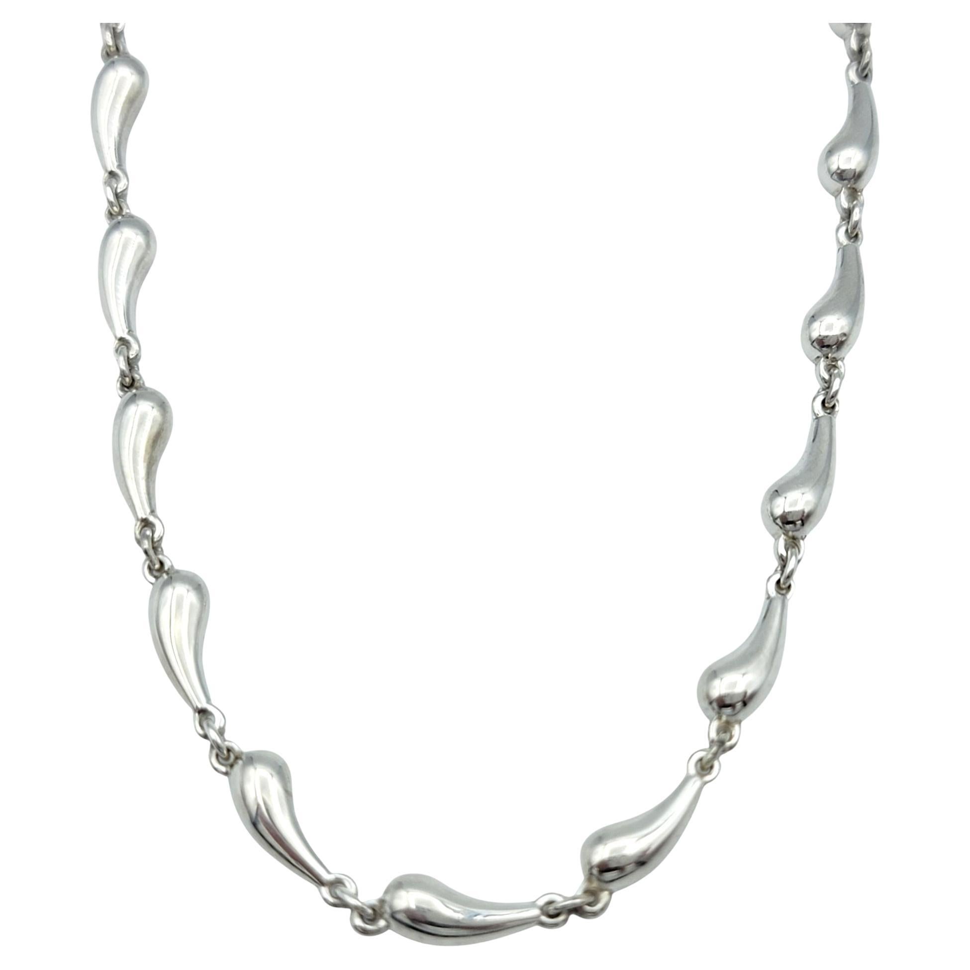 This stunning Tiffany & Co. teardrop link necklace is the perfect fusion of simplicity and sophistication. Designed by the iconic Elsa Peretti, the necklace features elegant teardrop-shaped links that flow seamlessly around the neck, creating a