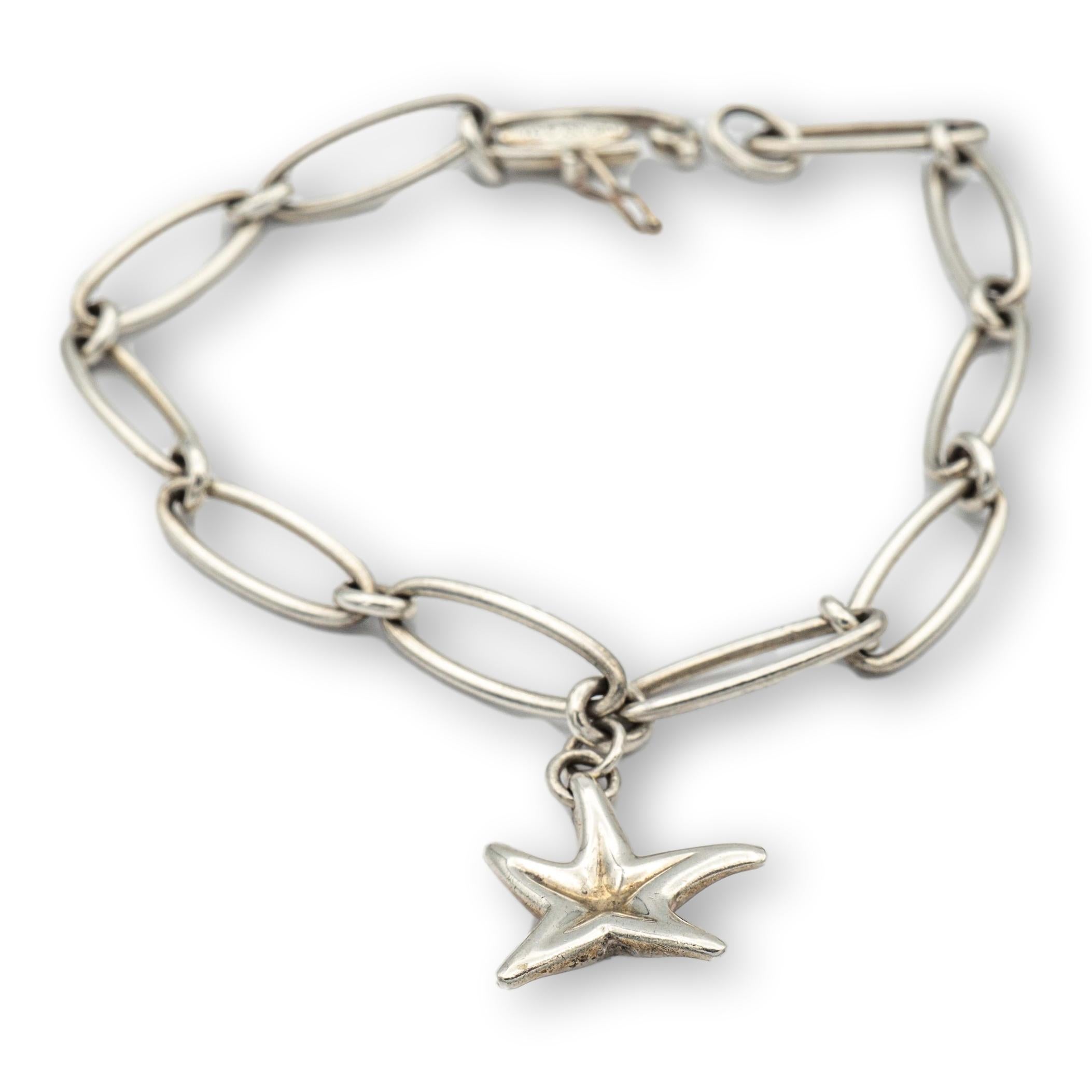 Tiffany & Co. bracelet finely crafted in sterling silver with starfish charm hanging off a large link bracelet that measures 7.5 