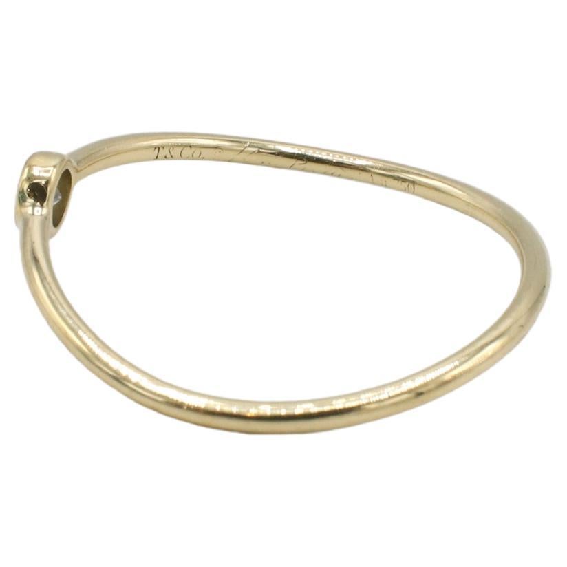 Tiffany & Co. Elsa Peretti Wave Thin Single Row 18 Karat Yellow Gold Natural Diamond Band Ring 
Metal: 18k yellow gold
Weight: 0.93 grams
Diamonds: 1 natural round diamond approx. 0.60 D VVS
Width: 1 - 3mm
Size: 7 (US)
Retail: $1,200 USD
LDD
