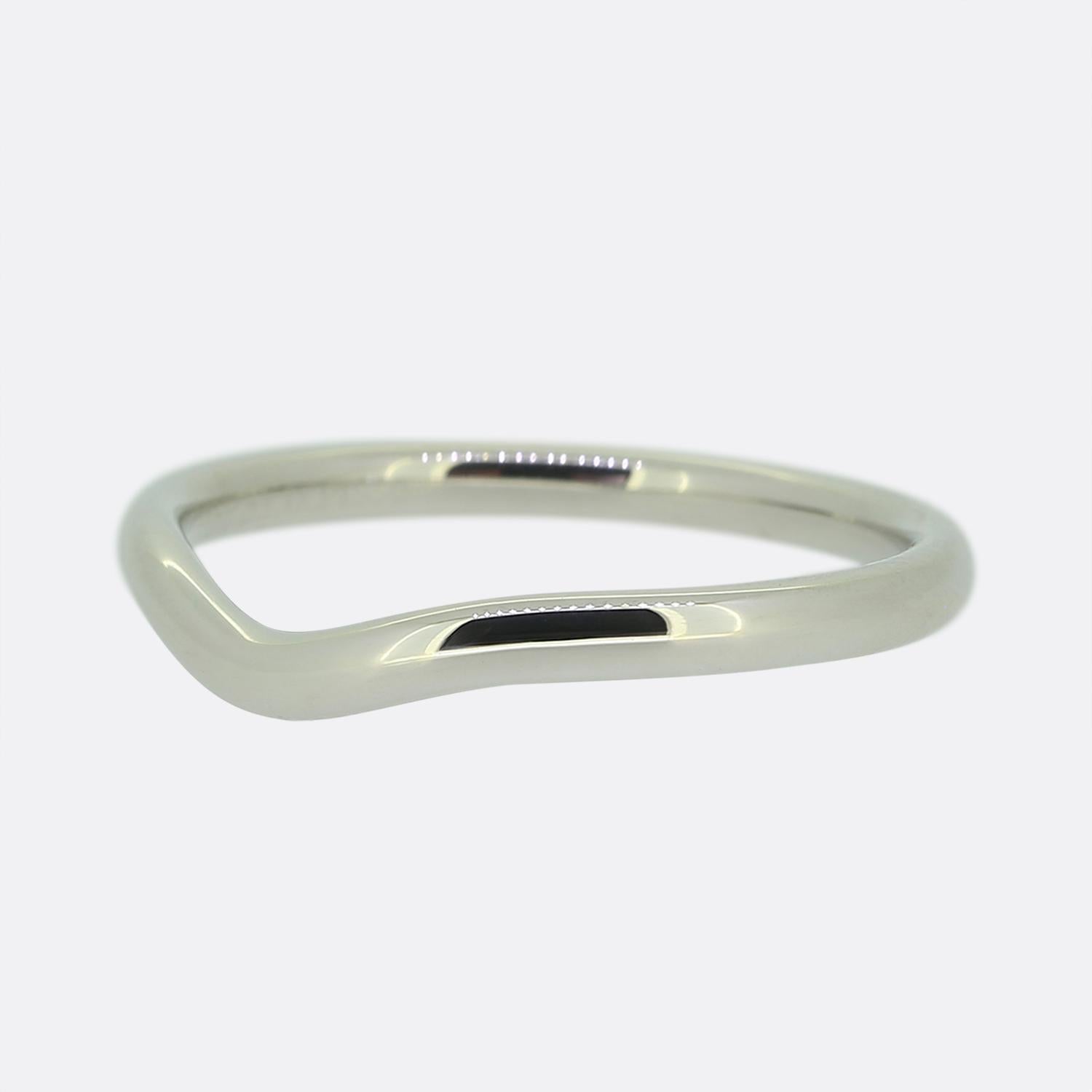Here we have a sleek platinum wedding band ring from Tiffany & Co. taken from an Elsa Peretti collection. The design features a subtle wave contour, adding a modern touch to its minimalist form allowing it to sit perfectly below a well suited