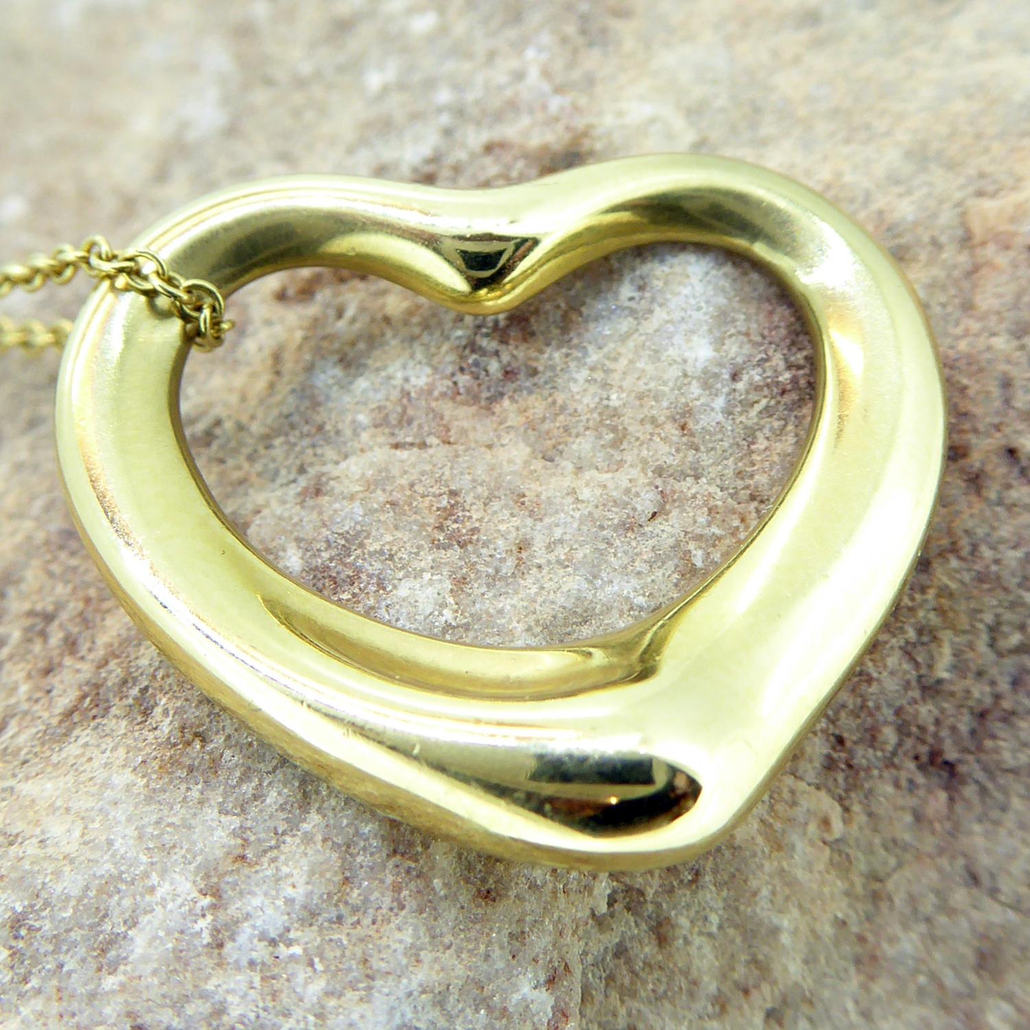 A pre-owned gold heart pedant from Tiffany, part of the Elsa Peretti collection for the iconic design house.  Crafted in 18ct yellow gold the heart measures approx. 22mm wide and suspends from a gold trace chain.  The pendant is polished and is