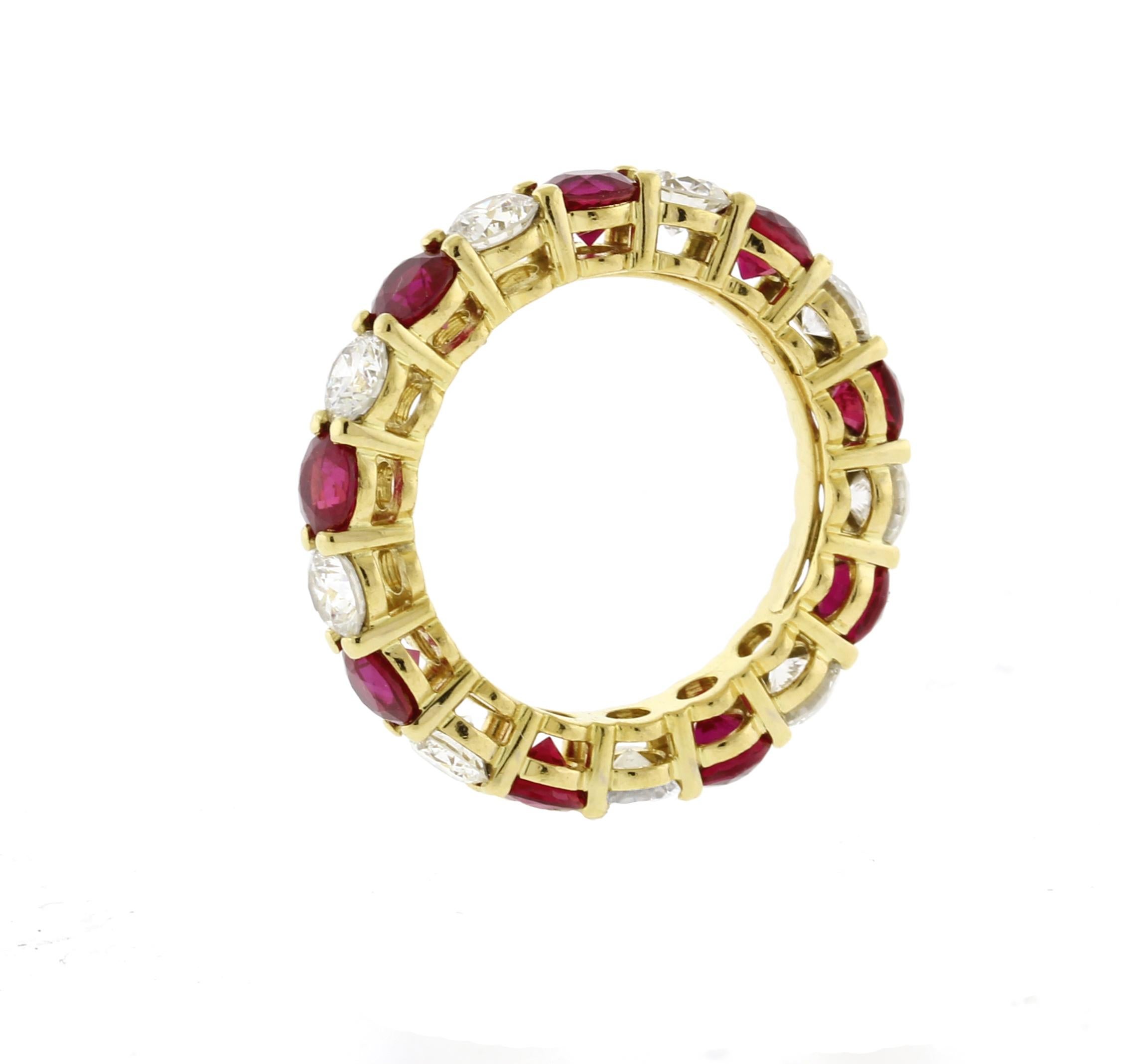 The Tiffany & Co. Embrace Ruby and Diamond Eternity Band features an elegant 18kt yellow gold setting with four and shared prongs securely holding 9 sparkling diamonds totaling approximately 1.50ct, paired with 9 vibrant rubies weighing around
