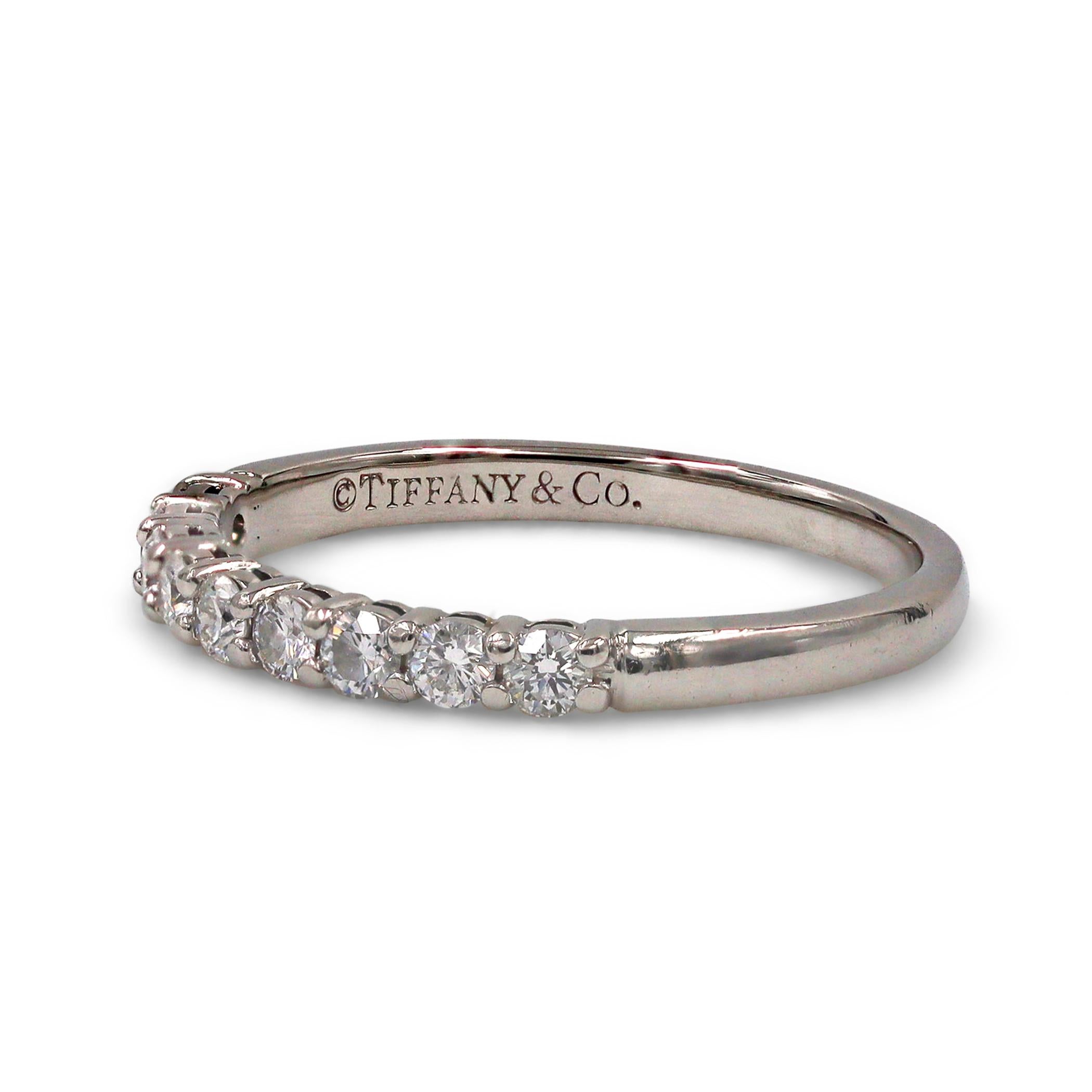 Authentic Tiffany & Co. band ring from the 'Tiffany Embrace' collection crafted in platinum and set with a half-circle of nine round brilliant diamonds for an estimated total weight of 0.27 carats. The band measures 2.2mm wide and is a US size 6.