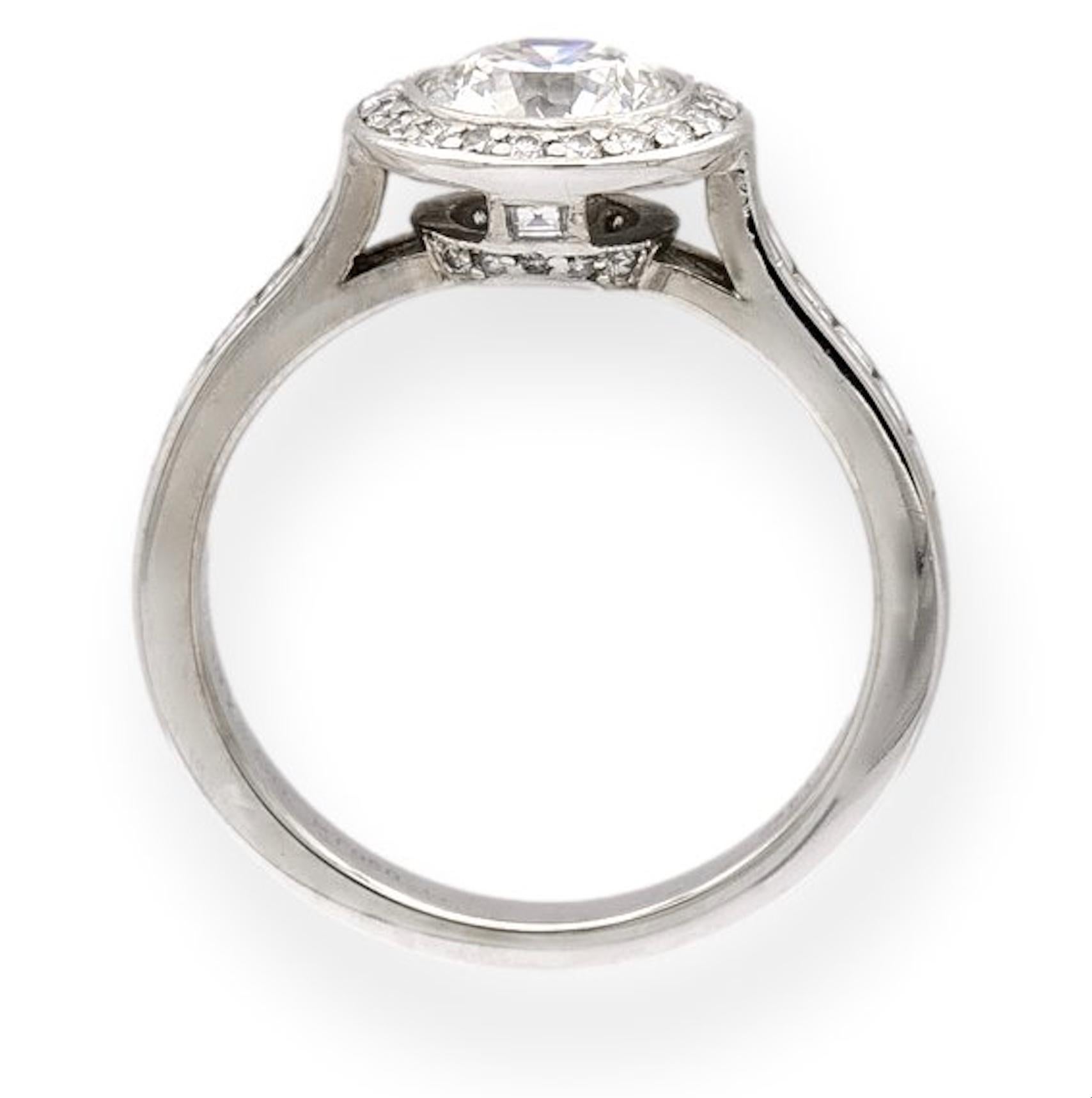 Tiffany & Co. engagement ring from the Embrace collection finely crafted in platinum featuring a round brilliant cut center diamond set in a bezel weighing 1.07 carats surrounded by a halo of channel set round brilliant cut diamonds and square