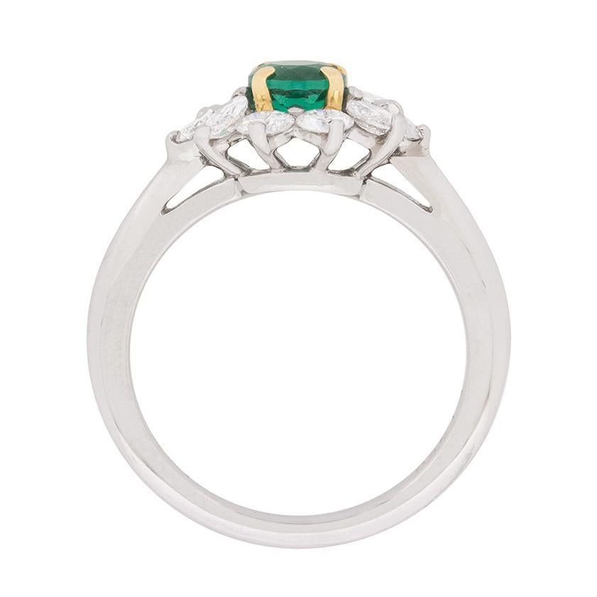 From Tiffany & Co. a stunning cluster ring centring a gorgeous 0.36 carat round emerald and a glittering ensemble of round brilliant and marquise cut diamonds. These diamonds, which total 0.70 carats, have been graded to a VVS clarity and bright
