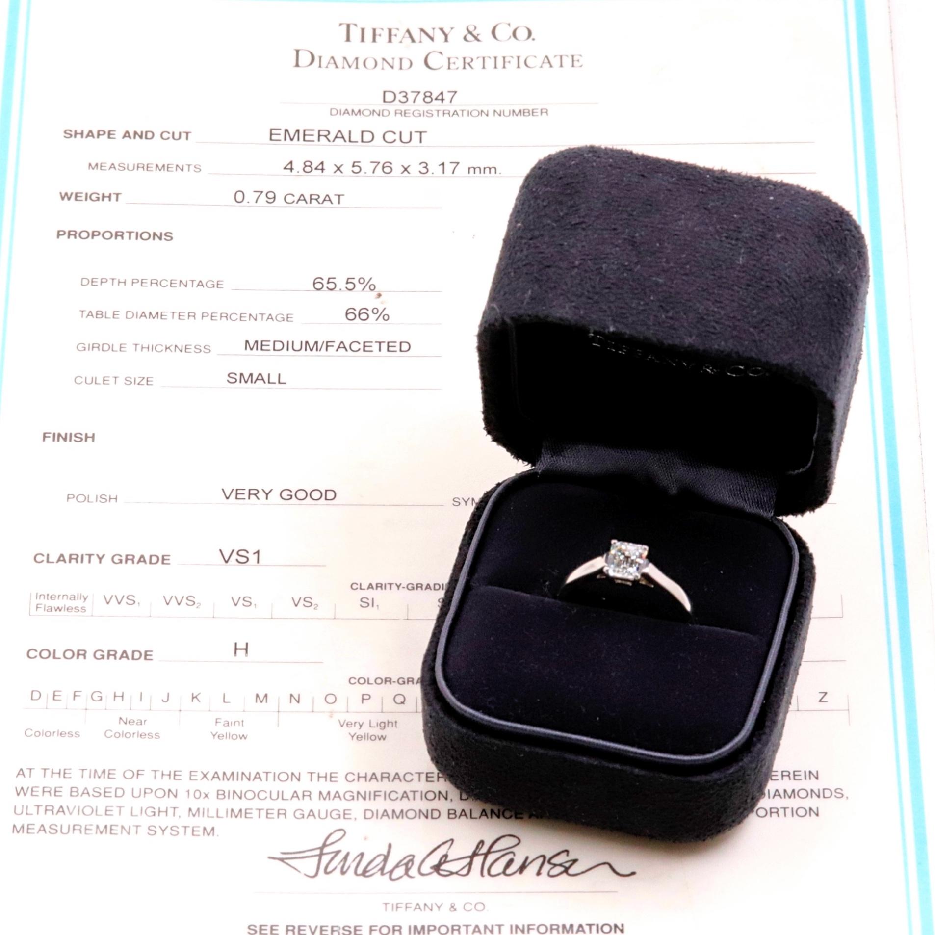 Tiffany & Co.

Style:  Emerald Diamond Solitaire Engagement Ring
Serial Number:  D37847
Metal:  Platinum PT950
Size:  6 - sizable
Total Carat Weight:  0.79 CTS
Diamond Shape:  Emerald Cut
Diamond Color & Clarity:   H - VS1
Hallmark:  TIFFANY&CO.