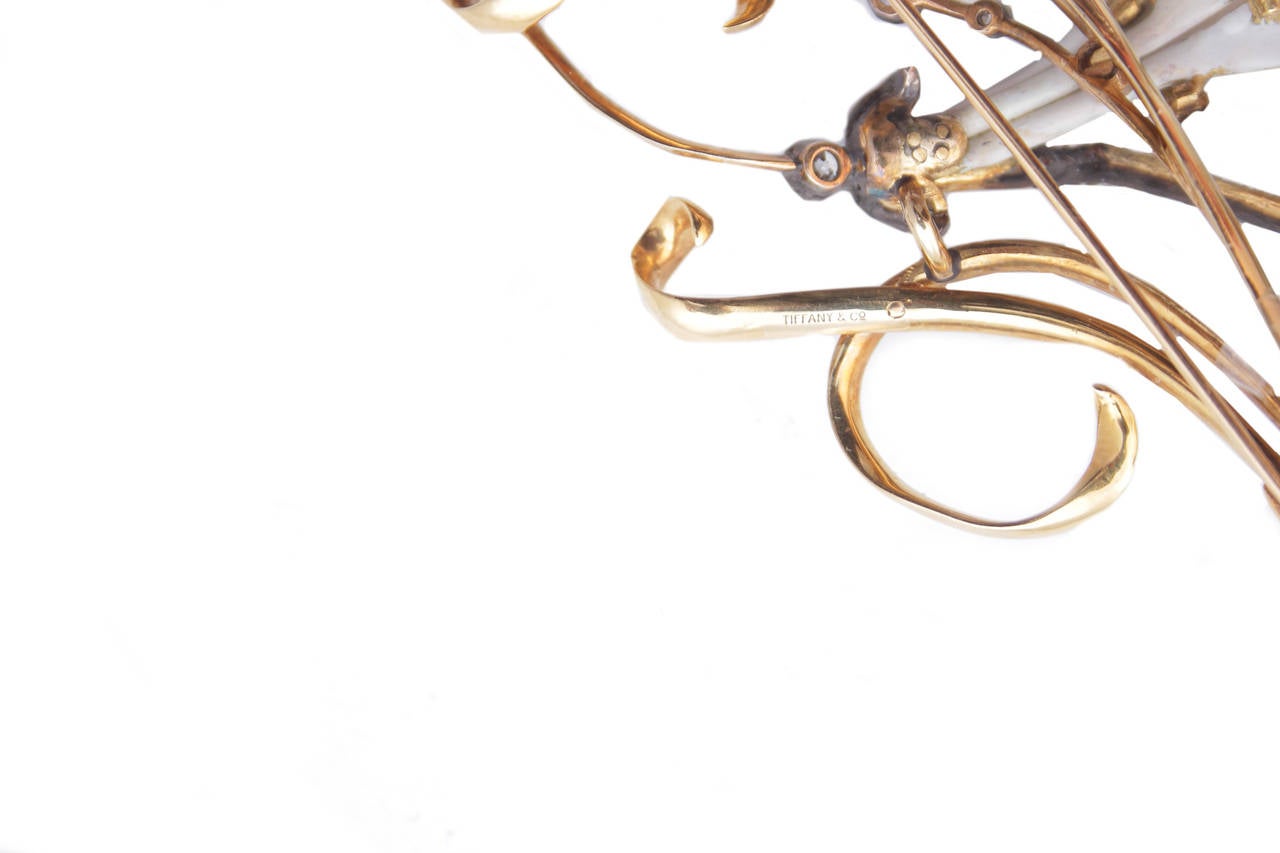 Rare broche présentant un motif floral articulé dans le style typique de l'Art Nouveau, rehaussé de diamants de taille ancienne et d'un fin émaillage blanc et rose sur une monture en or jaune de 18kt. Signé Tiffany & Co, c, 1905.