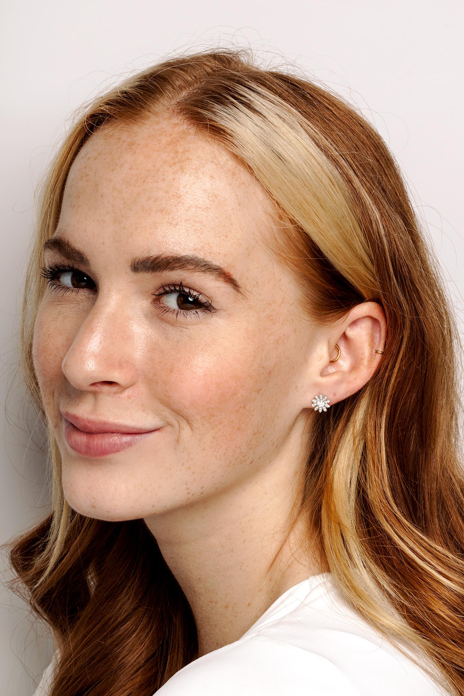 This charming pair of earrings come from Tiffany & Co.'s 'Enchant' collection. Made entirely from platinum in a flower design they feature a 0.20 carat round brilliant diamond in each earring. Along each of the ten petals on the flower design there