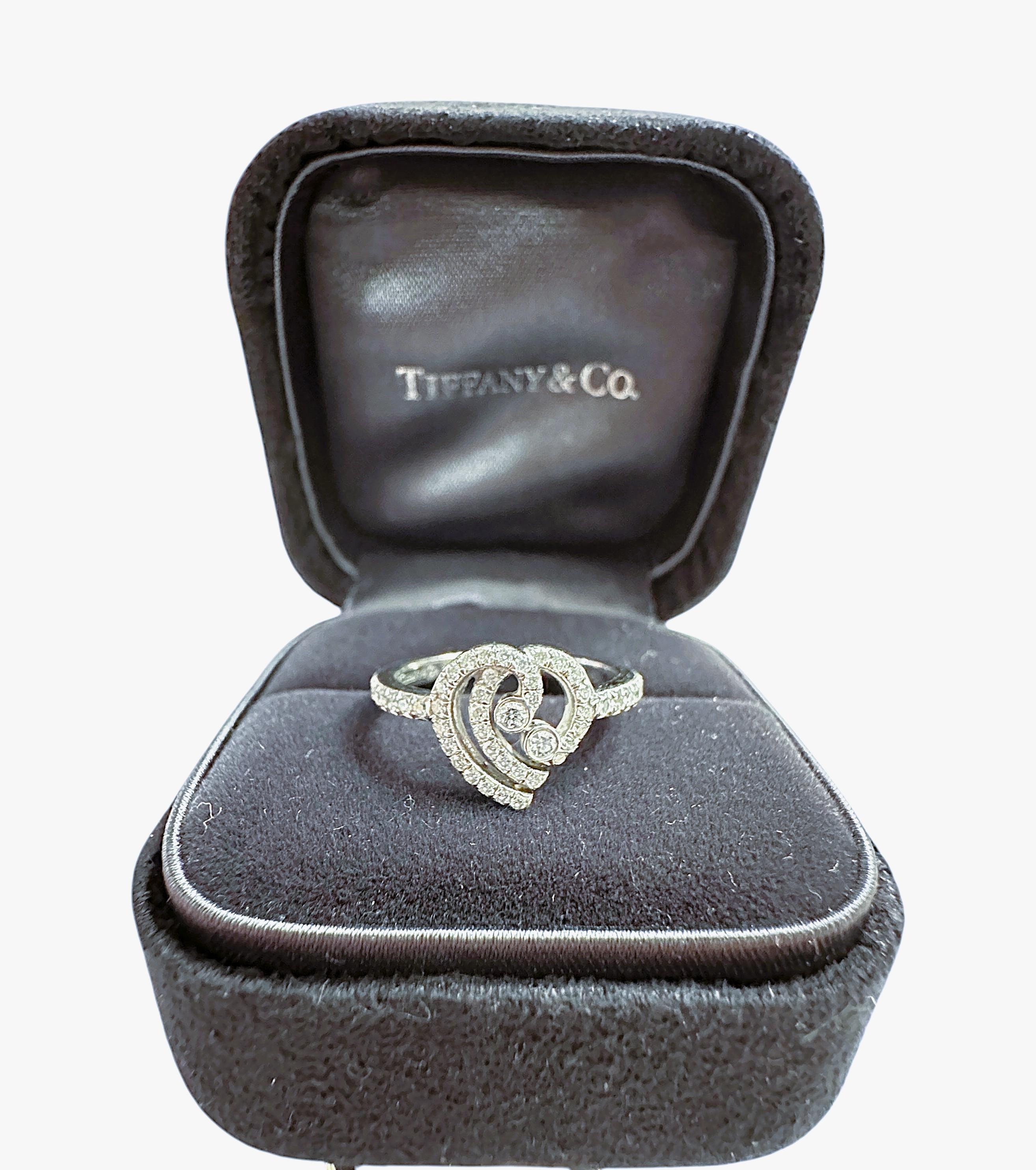 Beautiful and retired, Tiffany & Co Platinum Diamond Heart Ring by the Enchant Collection.  Elegant platinum ring features a double like heart with scrolls of sparkly brilliant cut diamonds around the heart and half way through the band.  Diamonds