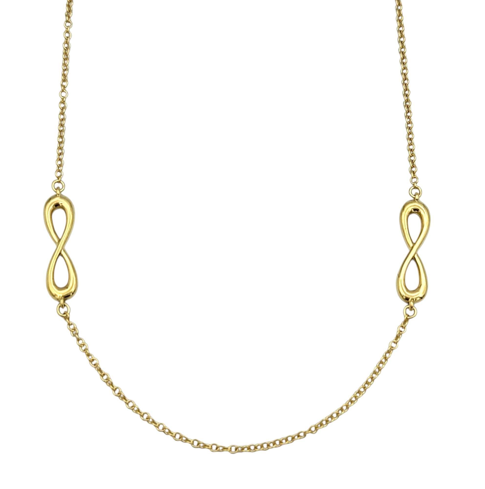 Questa autentica collana di Tiffany & Co. è una raffinata espressione di eterna eleganza, con al centro il motivo dell'infinito tipico del marchio. Realizzata in oro giallo 18 carati, la delicata catenina è completata dal design elegante e curvo del