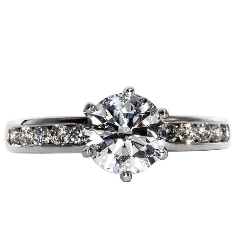 Classic Diamond Engagement Solitaire signed by Tiffany & Co. featuring a 1.43ct Center, graded G color , and VS1 Clarity.
Highlighted with 10 Channel set diamonds weigh approximately .35 Cts Total
With original papers.
Size 6 - This ring can be