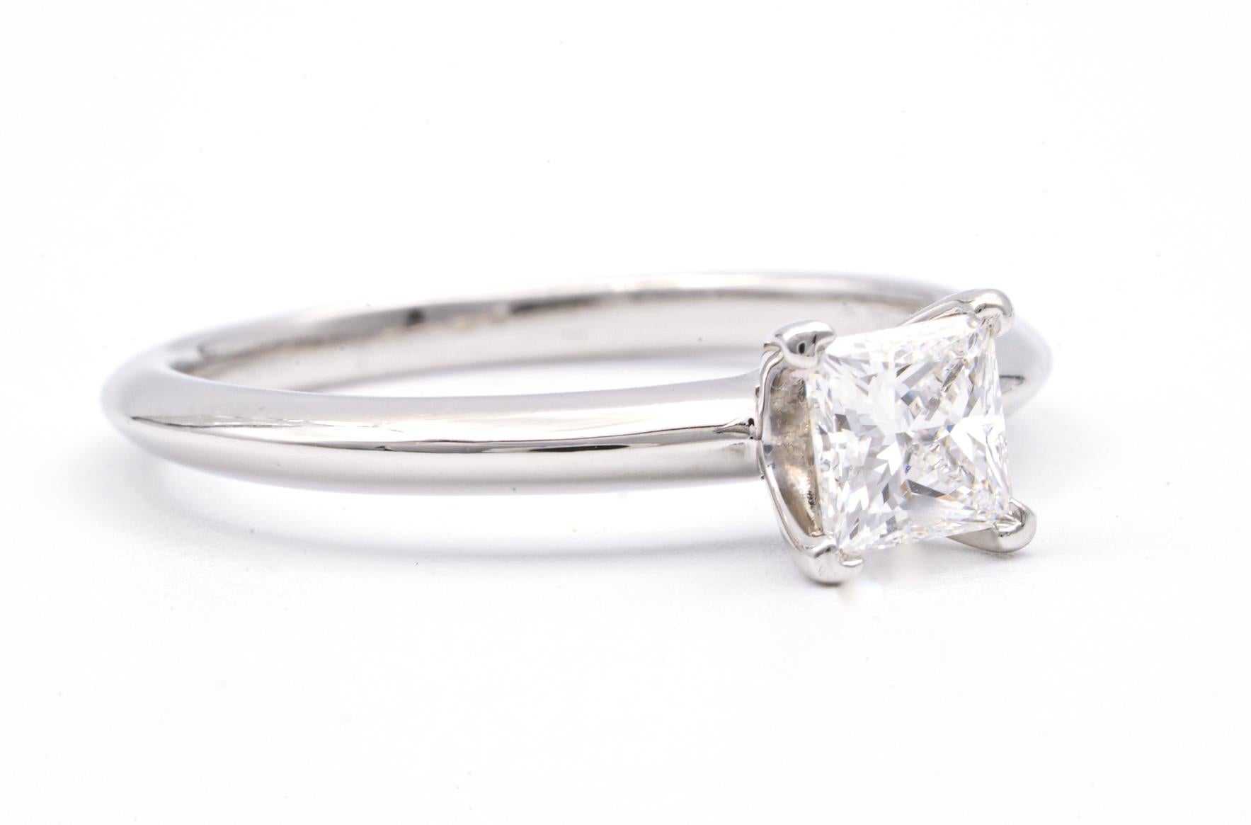 Classic Diamond Engagement Solitaire ring signed by Tiffany & Co. featuring a 4 prong set
0.54 ct Center princess cut diamond in platinum.
Graded by Tiffany E color , and VS2 Clarity.
Includes Original Tiffany Certificate and Box 
Crown Inscription