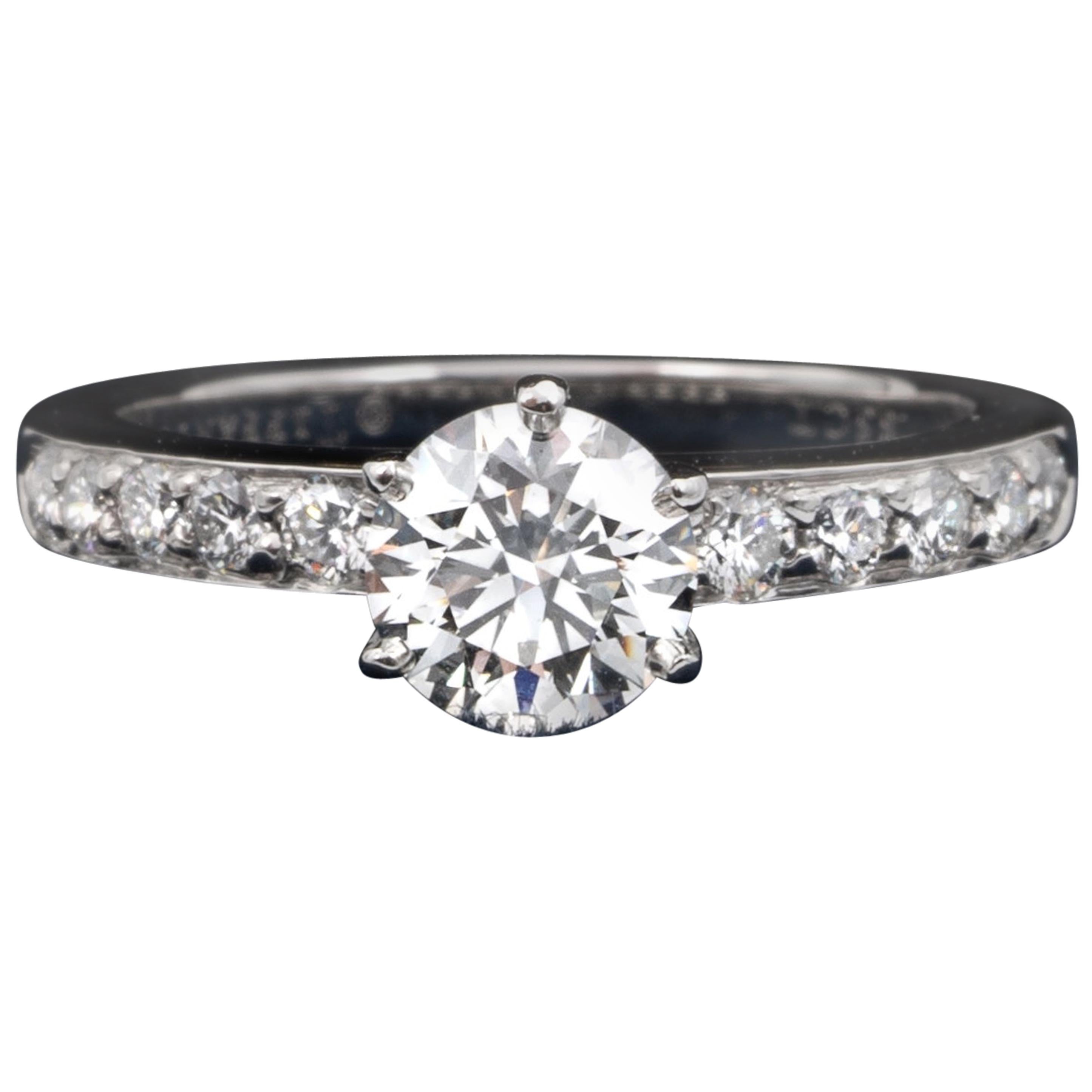 Tiffany & Co Diamond Engagement Solitaire signed by Tiffany & Co. featuring a .85 carat Center, graded G Color , and VS2 Clarity.
Highlighted with 10 brilliant cut round diamonds weighing approximately .24 Cts Total
With original papers.
Appraisal