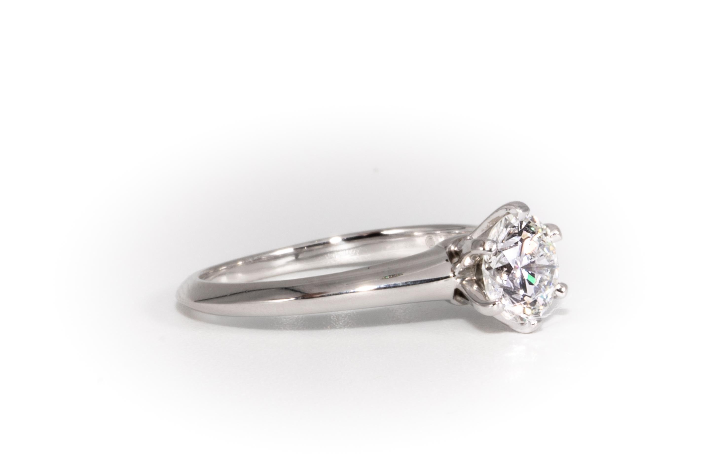 Tiffany & Co. Diamond Engagement Solitaire signed by Tiffany & Co. featuring a .91 ct Center, graded H color , and VS1 Clarity.
In Platinum

Crown Inscription: T&Co. 21193674
Includes Original Tiffany Certificate, and Box
Approximate Retail from