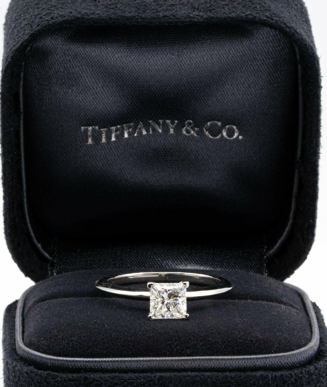 Classic Diamond Engagement Solitaire ring signed by Tiffany & Co. featuring a 4 prong set 0.94 ct Center princess cut diamond in platinum.Graded by Tiffany G color , and VS1 Clarity. Current Retail price : $9,600
Includes Original Tiffany
