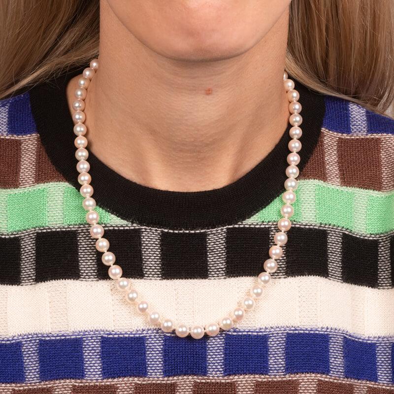 This classic pearl necklace features approximately 6.5-7 mm Akoya cultured pearls and an 18 karat white gold clasp and decorative tag inscribed with 
