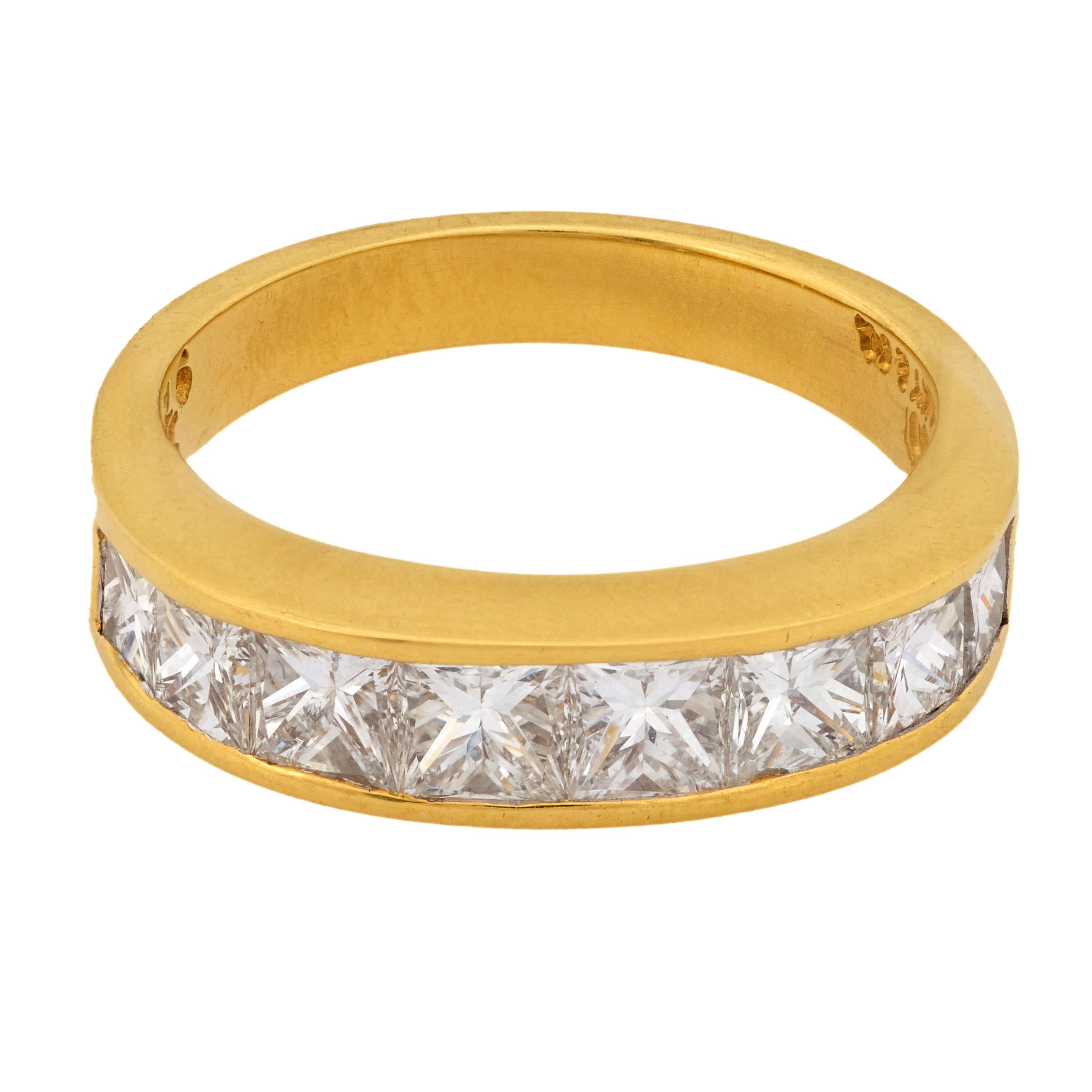 Una fabulosa media banda de diamantes de la legendaria joyería Tiffany & Co. Este elegante anillo está fabricado en vibrante oro amarillo de 18 quilates y presenta una hilera de 8 diamantes talla princesa que atraviesan horizontalmente la parte
