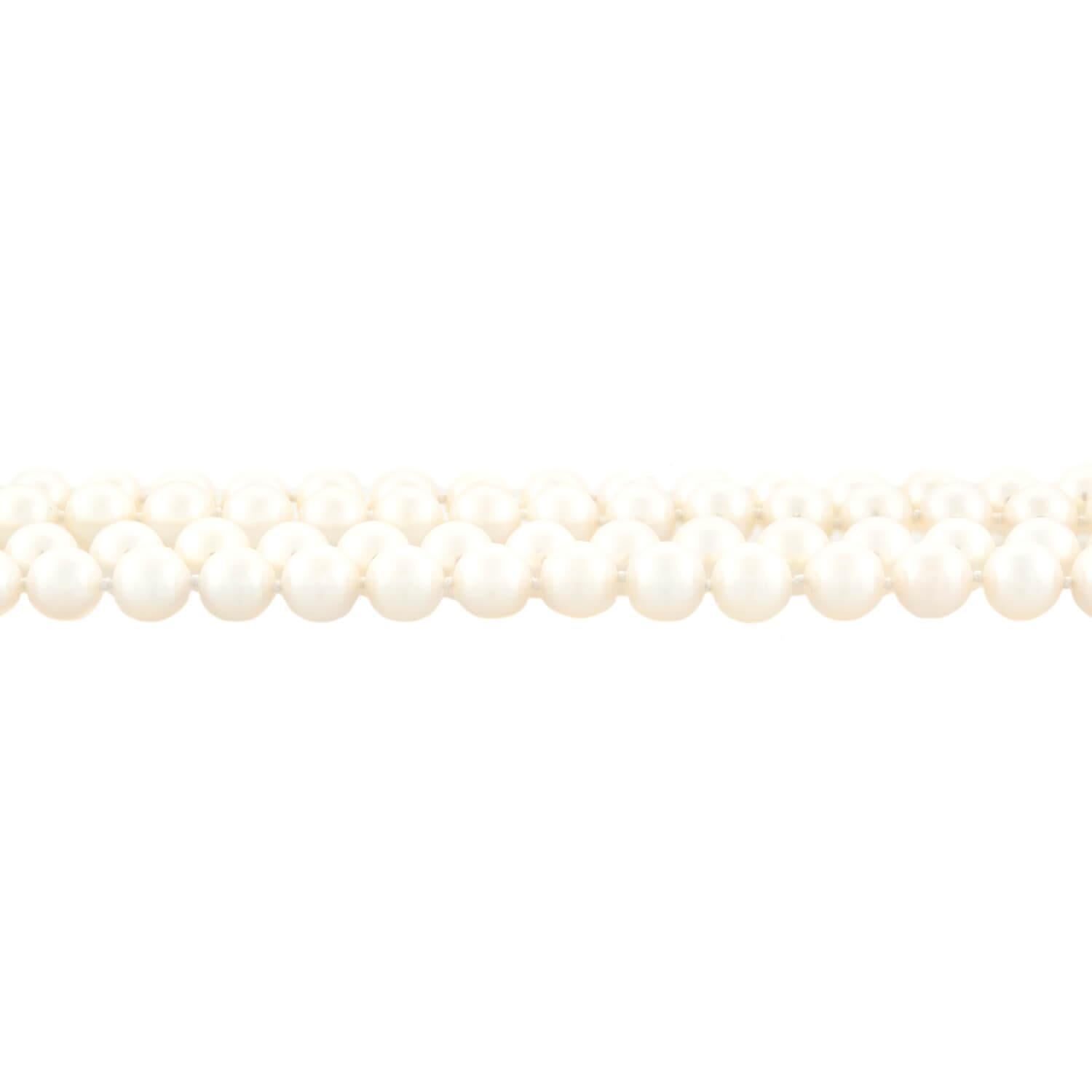 A classically beautiful two-strand pearl necklace from legendary designer Tiffany & Co.! The luminous pearls are hand-knotted on ivory-colored thread and exhibit a creamy white color and exceptional luster. The two strands secure at a large 18k