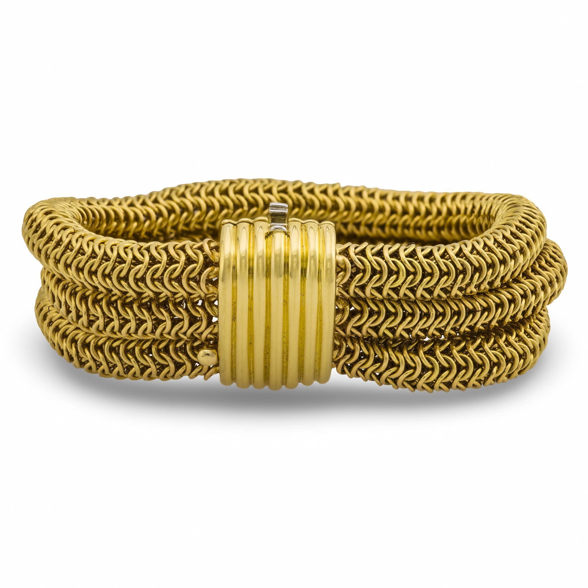 An extraordinary gold bracelet by Tiffany & Co.! Crafted in vibrant 18k yellow gold, this bracelet is comprised of 3 thick gold braided strands. The strands have a fantastic flexible design. The piece is secured by a simple push hook clasp.The latch