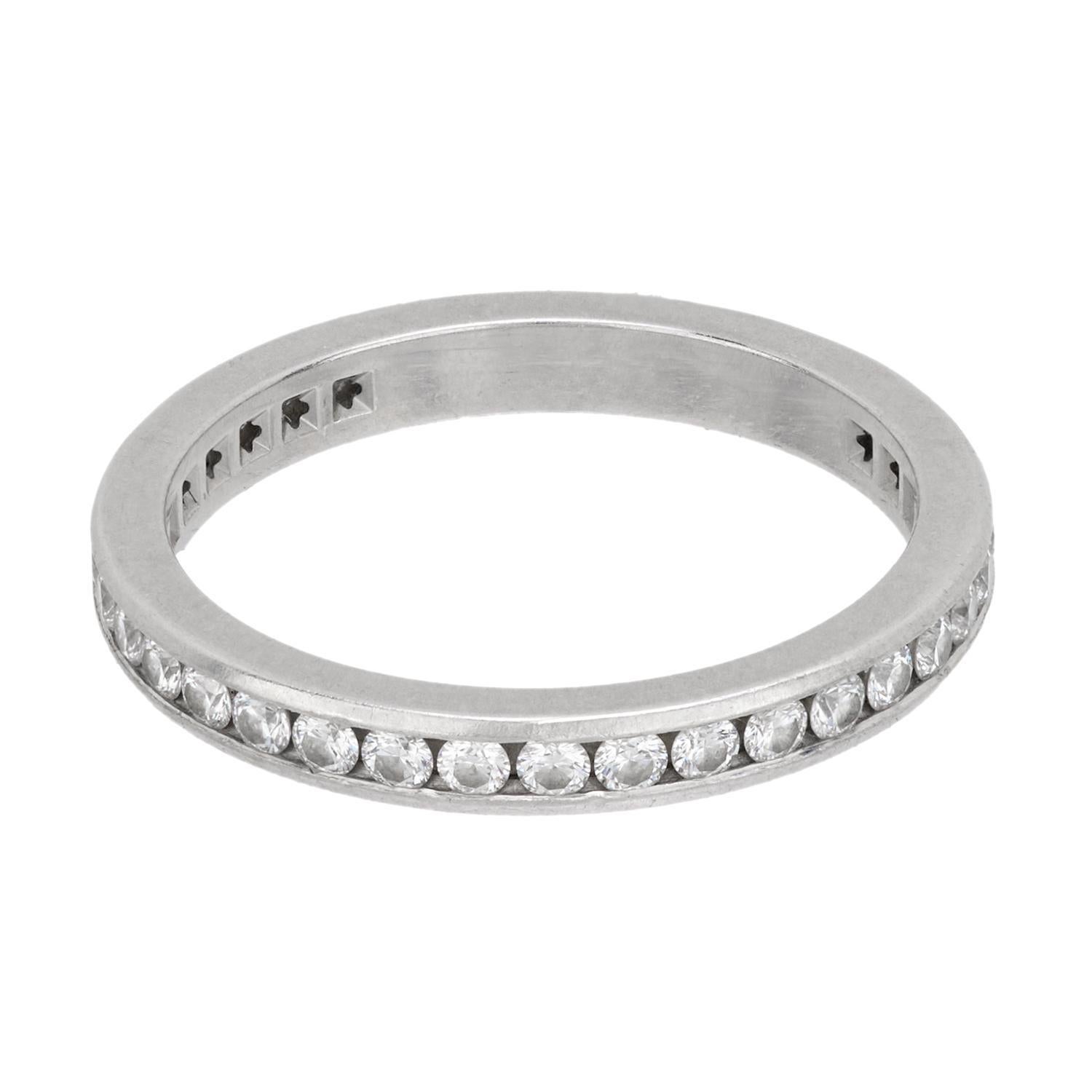 This gorgeous diamond eternity band is a signed Tiffany & Co. piece! Crafted in platinum, the ring features a single row of modern round brilliant cut diamonds, which carry all the way around the outer surface in a continuous channel setting. The