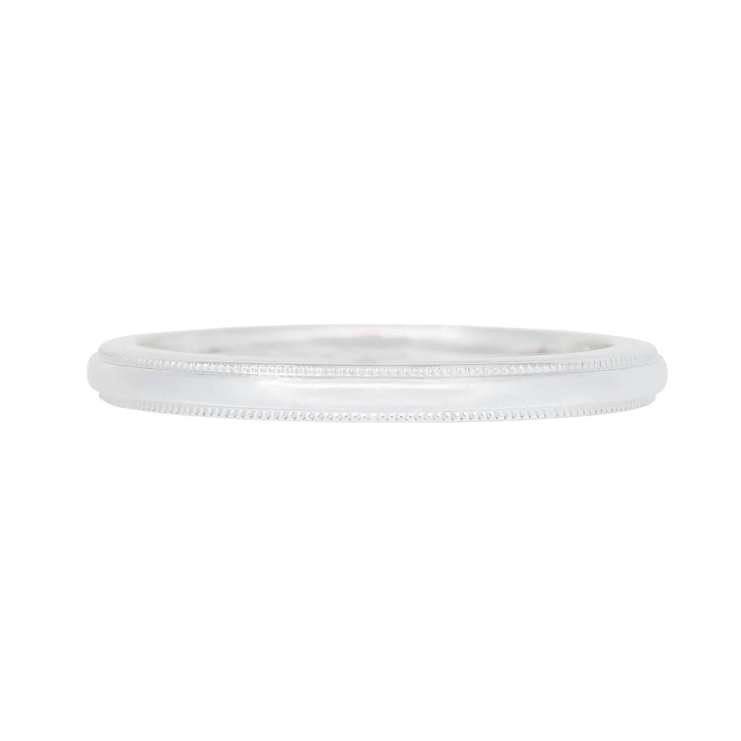 A simple and classic ring from iconic jeweler,Tiffany & Co.! This lovely piece is crafted in solid platinum and forms a smooth and simple band. The top and bottom edge of the band feature a border of small, three-dimensional balls, which carry