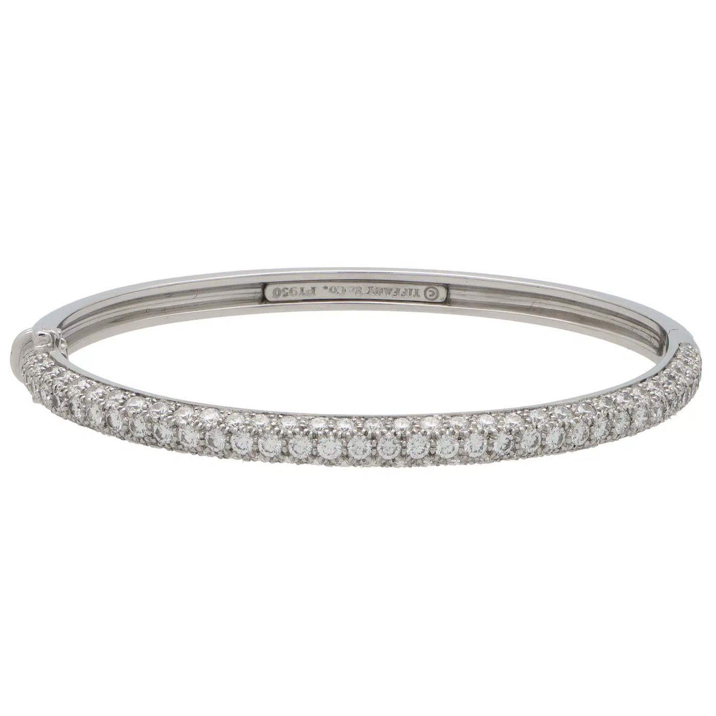 This Tiffany & Co Etoile piece is composed of a solid bangle that is hinged to one side with a secure click shut and safety catch fitting. One side of the bangle is fully pave set with round cut diamonds which looks spectacular once on the wrist.