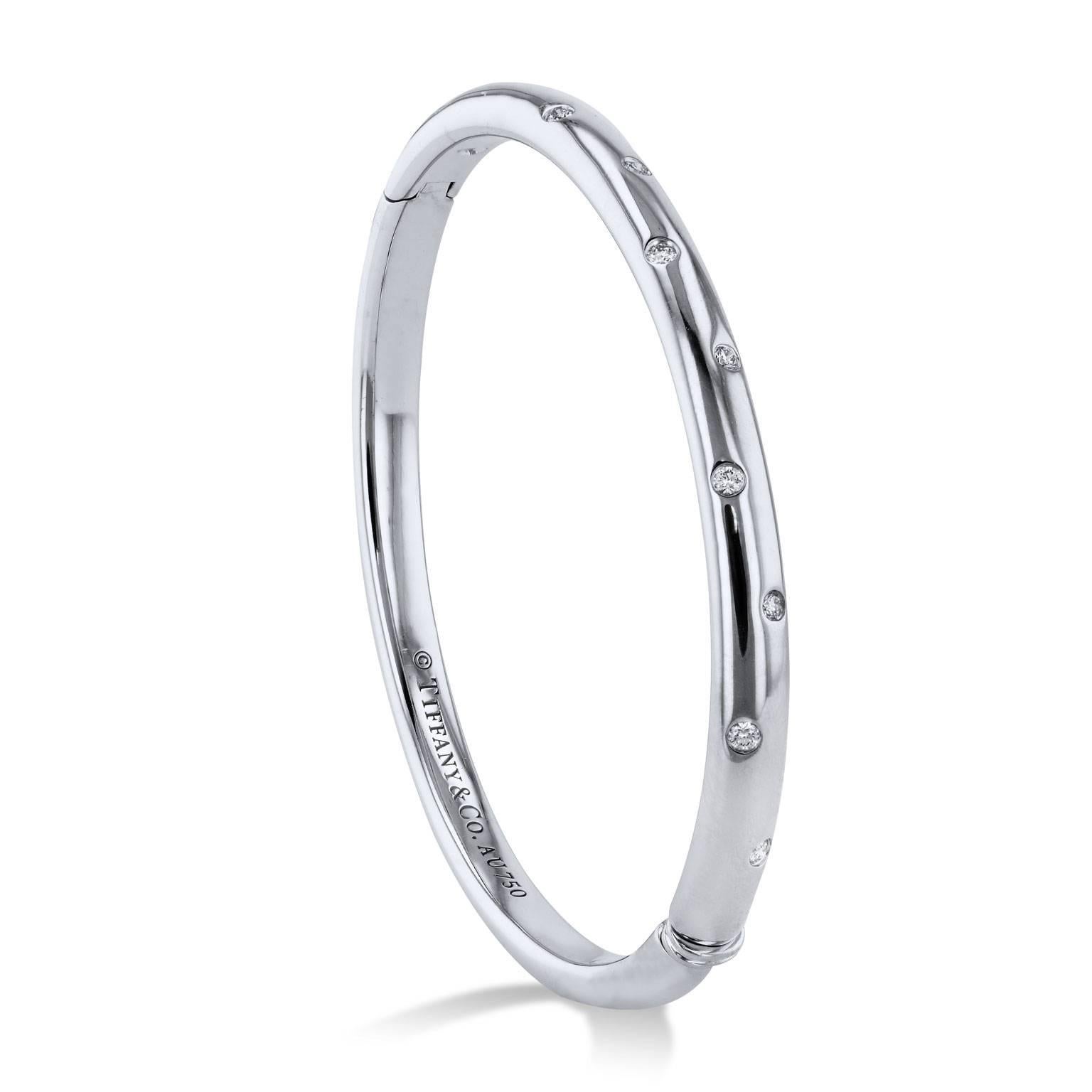 Enjoy this previously loved Tiffany & Co. Etoile Collection 18 karat white gold bangle bracelet featuring 0.21 carat of diamond in flush setting (size medium; fits 6.25 inch wrist).