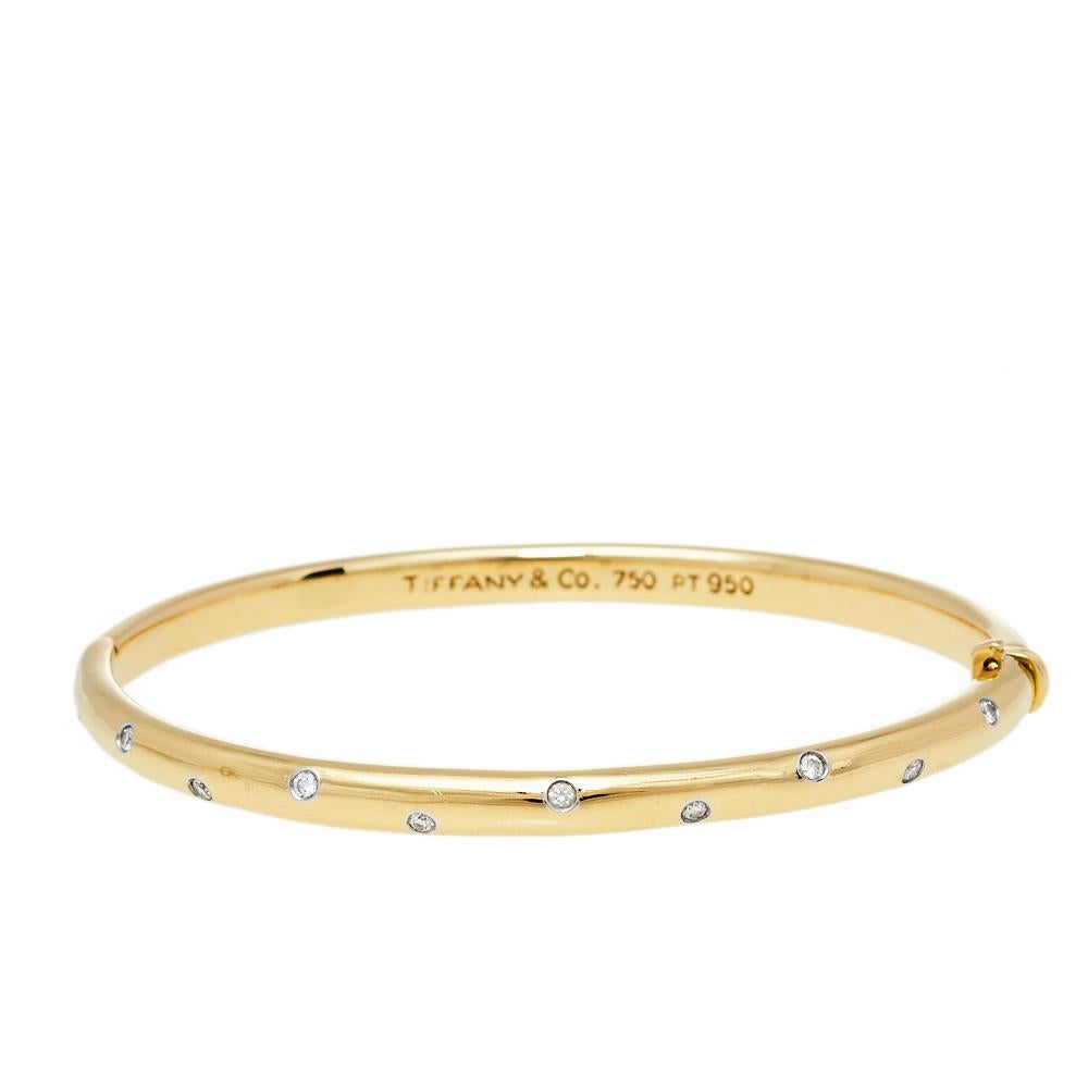 Charming jewelry lovers since 1837, Tiffany & Co. stands as a true symbol of exquisite craftsmanship and attention to detail. This magnificent bangle bracelet is brought to life using 18K yellow gold and platinum and studded with dazzling diamonds.