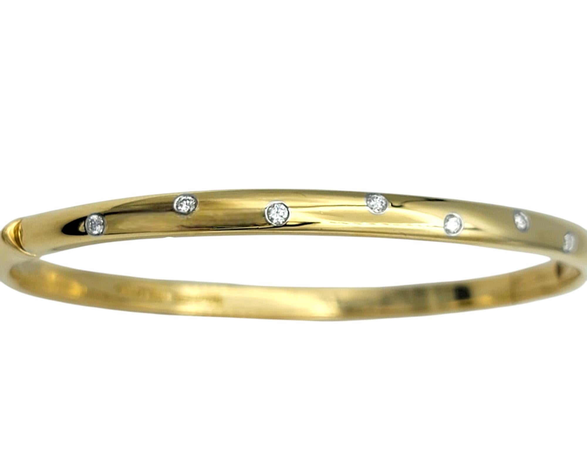 This elegant Etoile bangle bracelet by Tiffany & Co. is a masterpiece of refined simplicity and modern sophistication. Crafted in a luxurious combination of 18 karat yellow gold and platinum, the design features a seamless, polished finish that