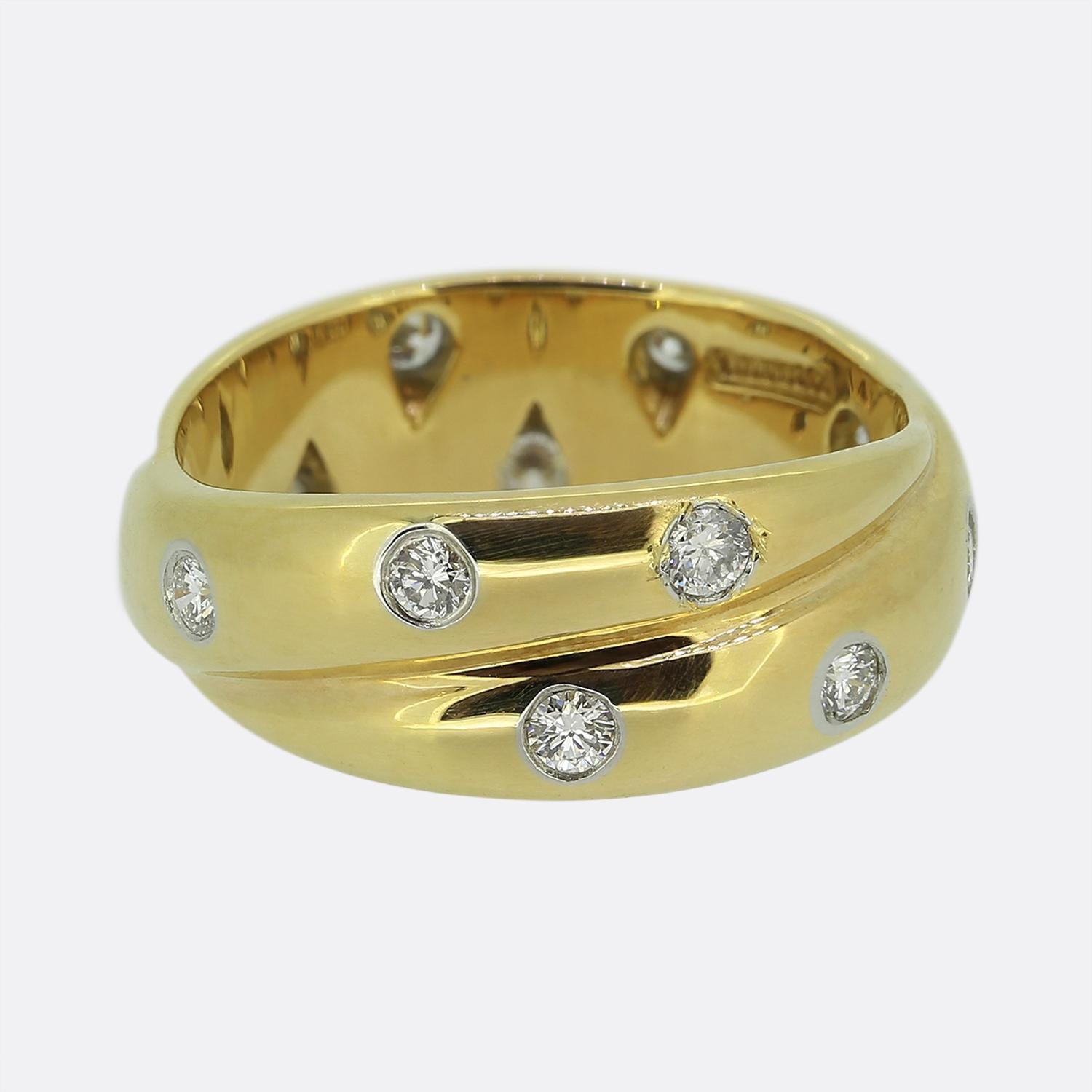 Aquí tenemos un icónico anillo de eternidad de doble banda del mundialmente conocido diseñador de joyas Tiffany & Co. Elaborada en oro amarillo de 18 quilates, esta pieza vintage forma parte de la colección Etoile de Tiffany y exhibe doce diamantes