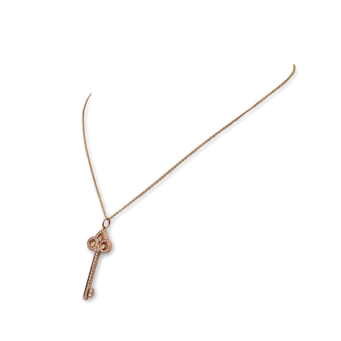 Authentic Tiffany & Co. 'Fleur de Lis' pendant crafted in 18 karat rose gold features a key design set with round brilliant diamonds for an estimated .40 carat total weight. This stunning pendant measures 1.44 inches in length. The pendant hangs in