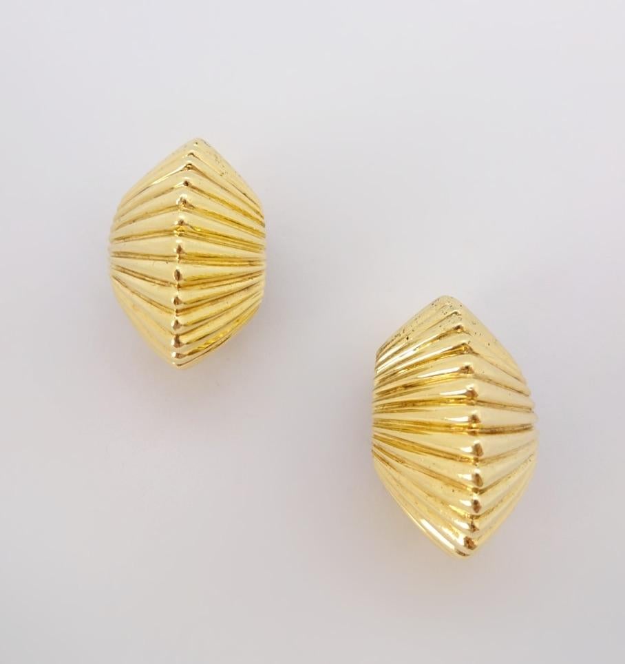 Versatile fluted gold ear clips, by Tiffany & Co. are 18K yellow gold with a tapered, ridged shape to compliment the face.


