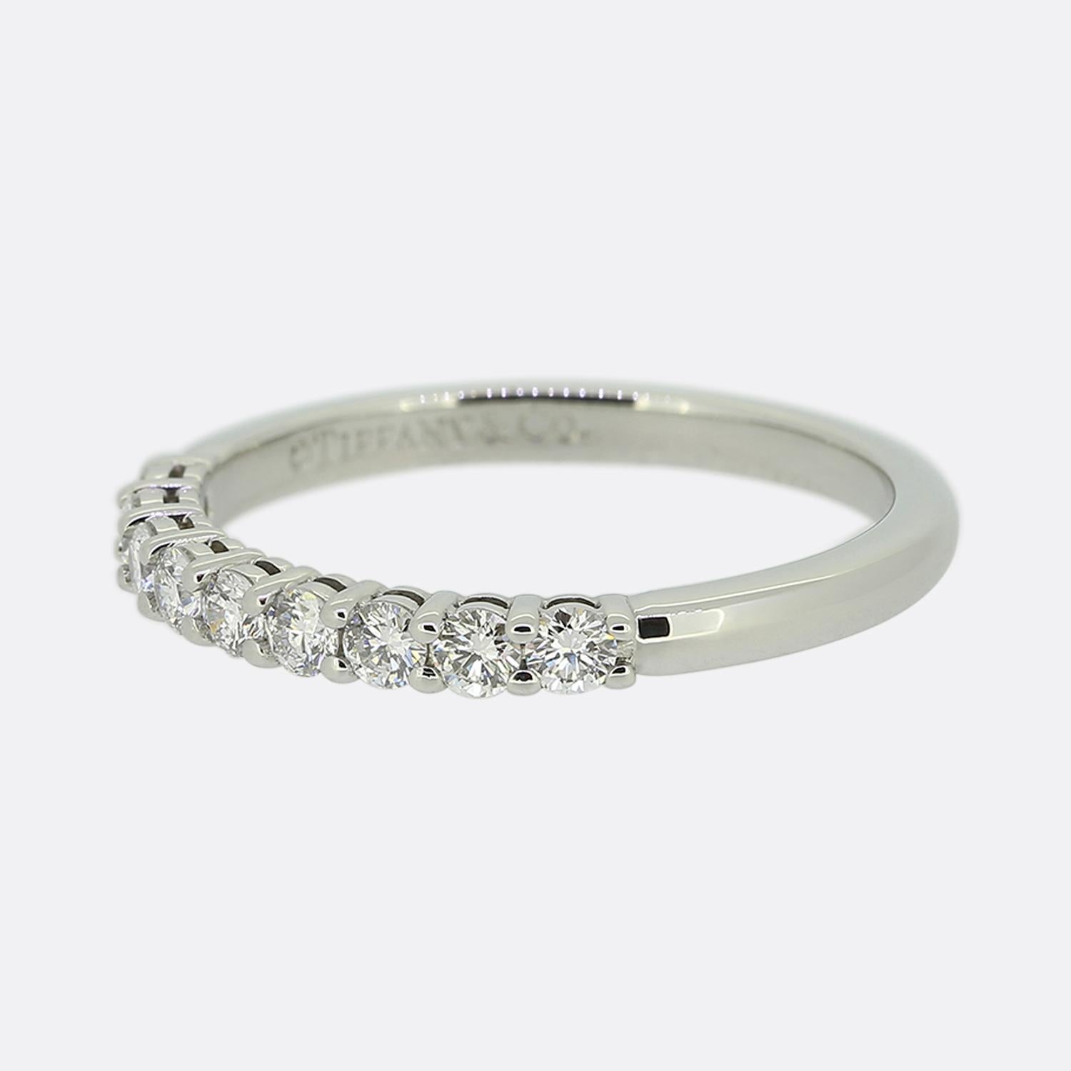 Hier haben wir einen wunderschönen Neunstein-Diamantring des weltbekannten Schmuckdesigners Tiffany & Co. Dieses aus Platin gefertigte Schmuckstück zeigt einen Halbkreis aus perfekt aufeinander abgestimmten runden Diamanten im Brillantschliff, die