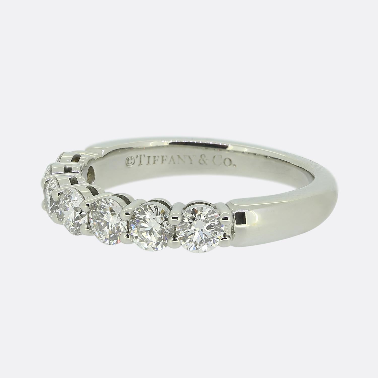 Here we have a wonderful seven-stone diamond ring from the world renowned jewellery designer, Tiffany & Co. This piece has been crafted from platinum and features a half circle of perfectly matched round brilliant cut diamonds in a single line