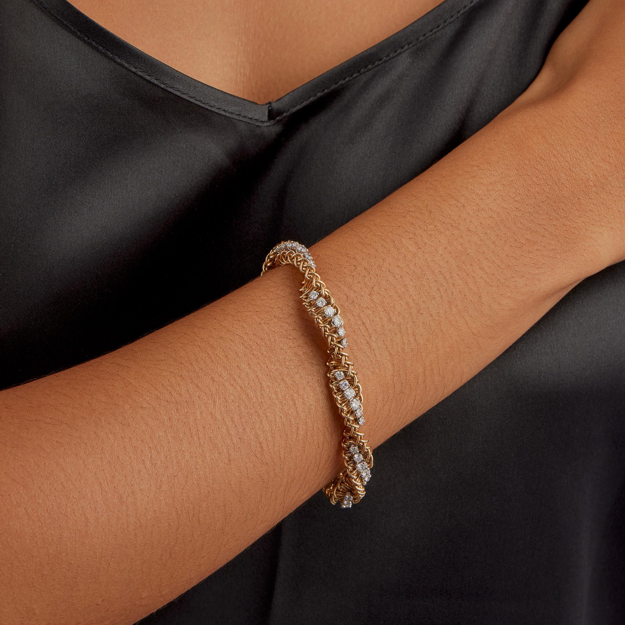 Created in the 1960s-1970s, this 18k gold ropetwist bracelet is set with over 5 carats of round brilliant-cut diamonds. It is designed as a twisting double helix of interlocking woven double wire, set at intervals with lines of round brilliant-cut